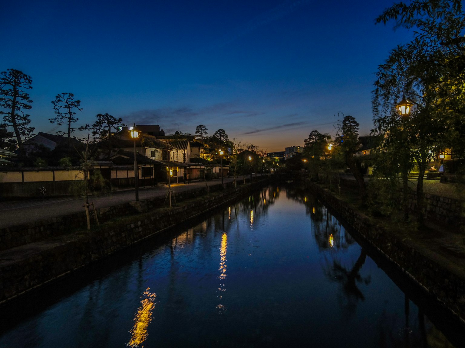 Nighttime view of a river with reflections of streetlights