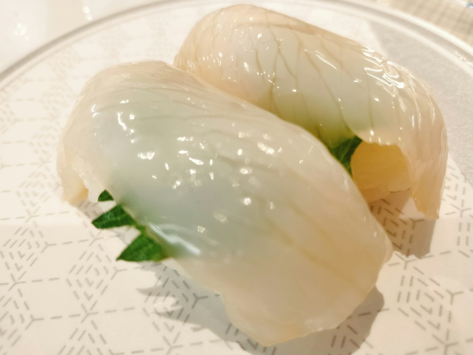 两块新鲜白鱼握寿司配绿叶