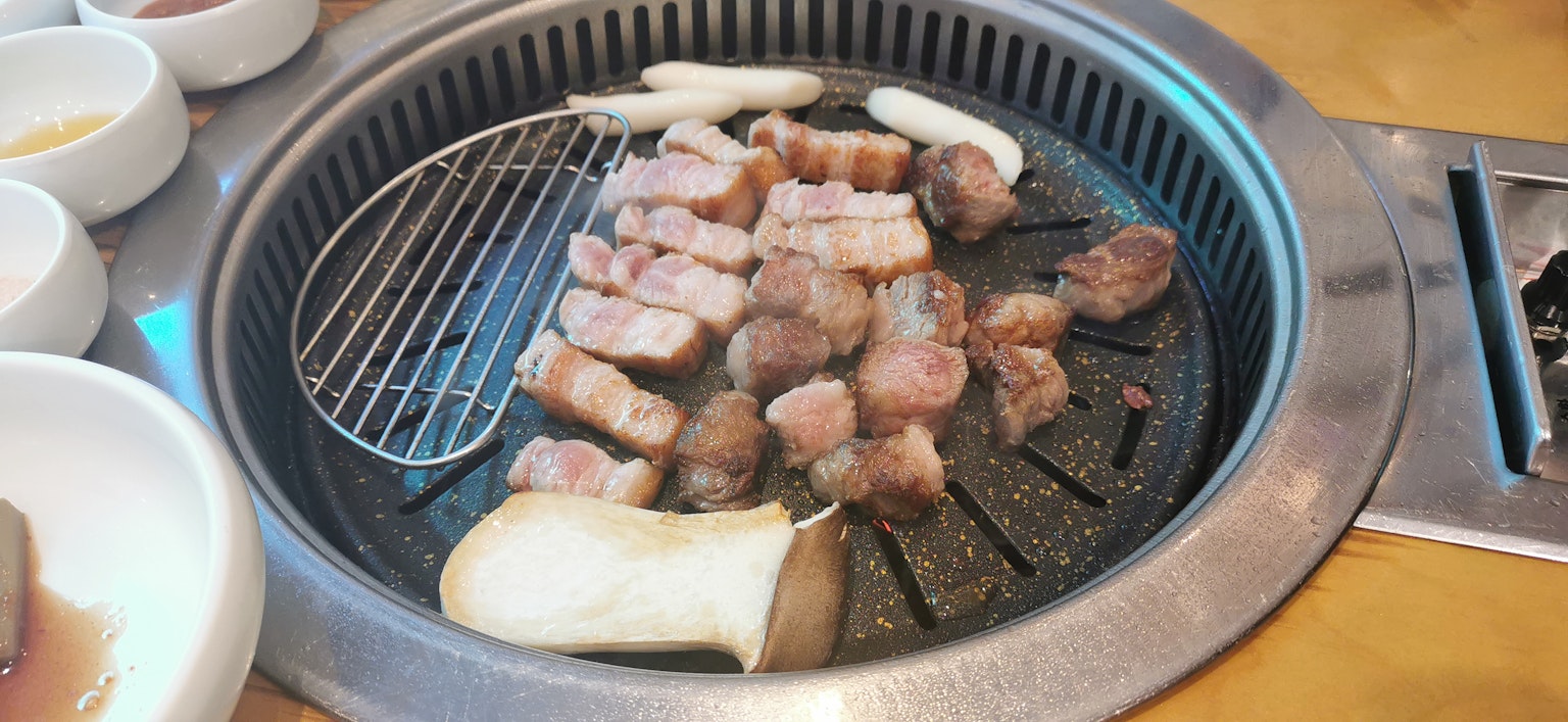 Carne e verdure che cuociono su una griglia coreana