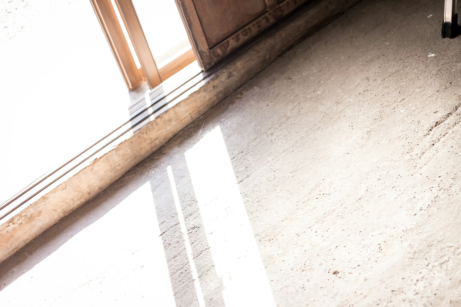 Sunlight streaming through an open window casting shadows on the floor