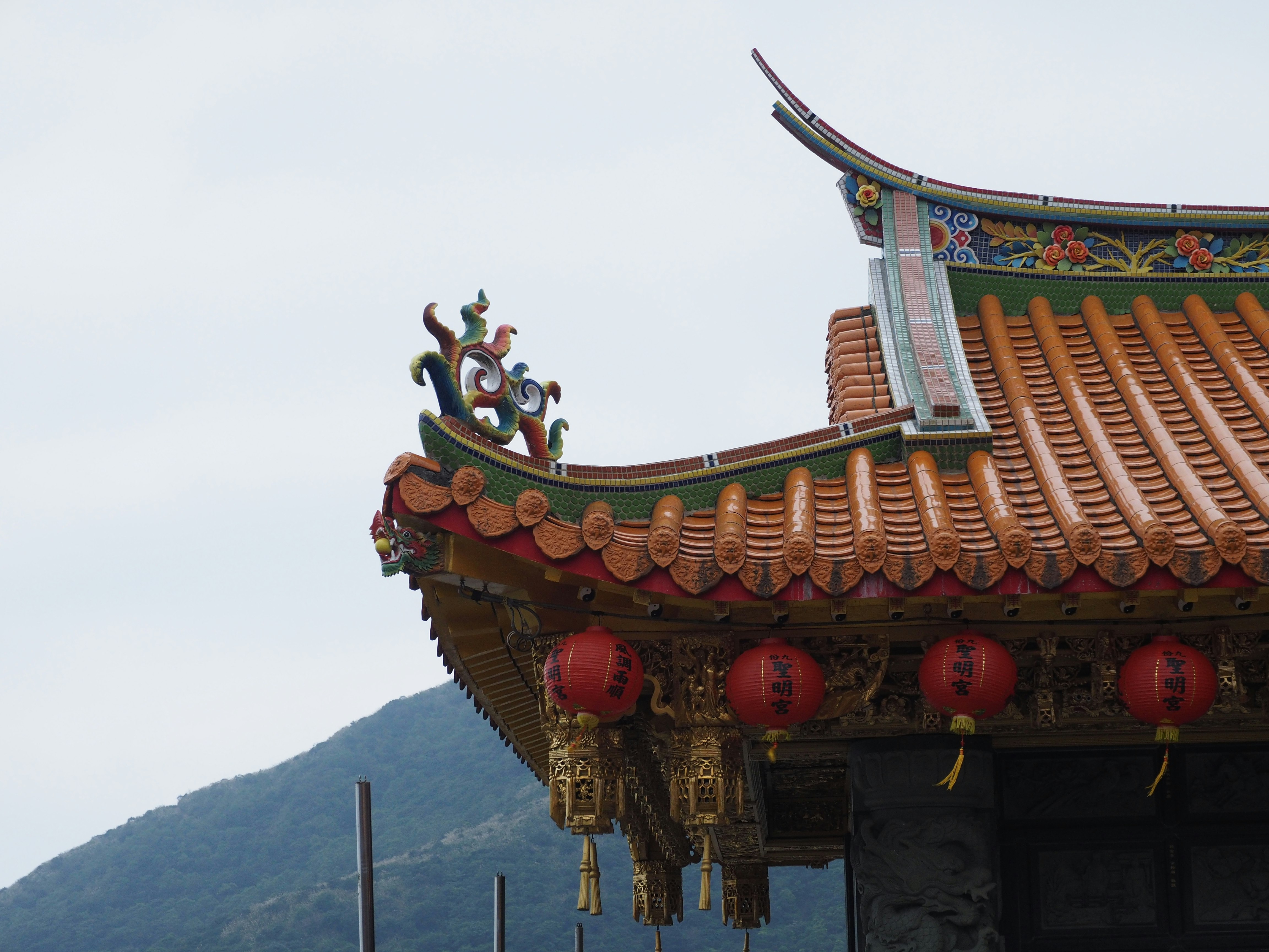 adornos ornamentales del tejado de un templo con montañas al fondo