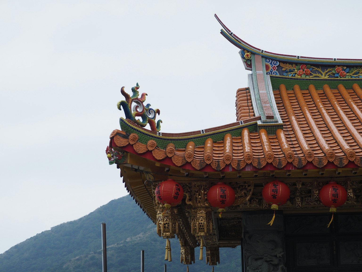 傳統中國建築屋頂細節，帶有裝飾元素和紅色燈籠