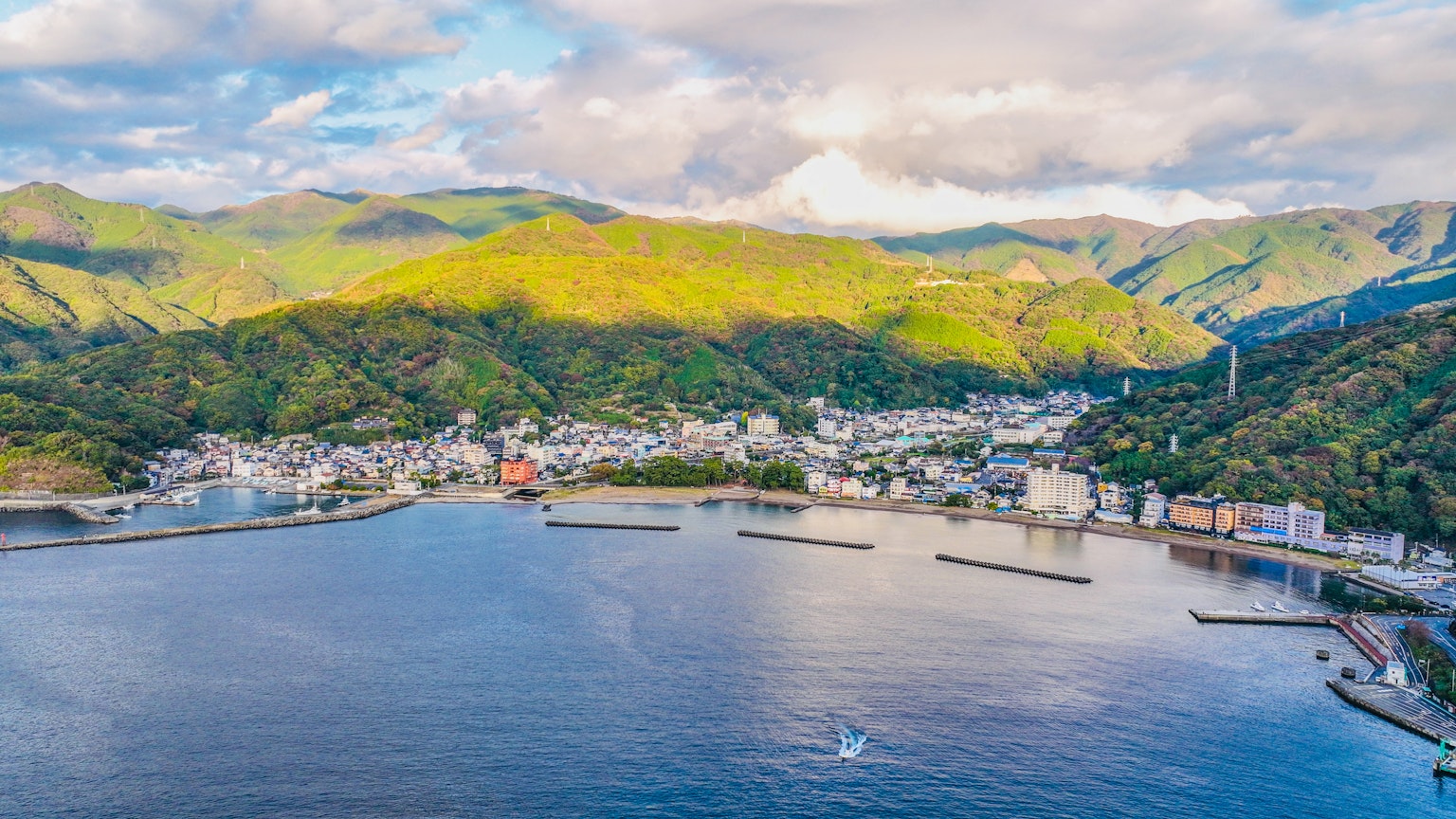 Luftaufnahme einer Stadt umgeben von Meer und Bergen