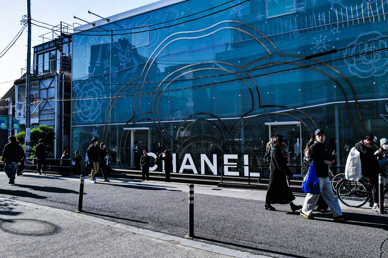 Persone che camminano su Cat Street davanti a un edificio con un murale blu