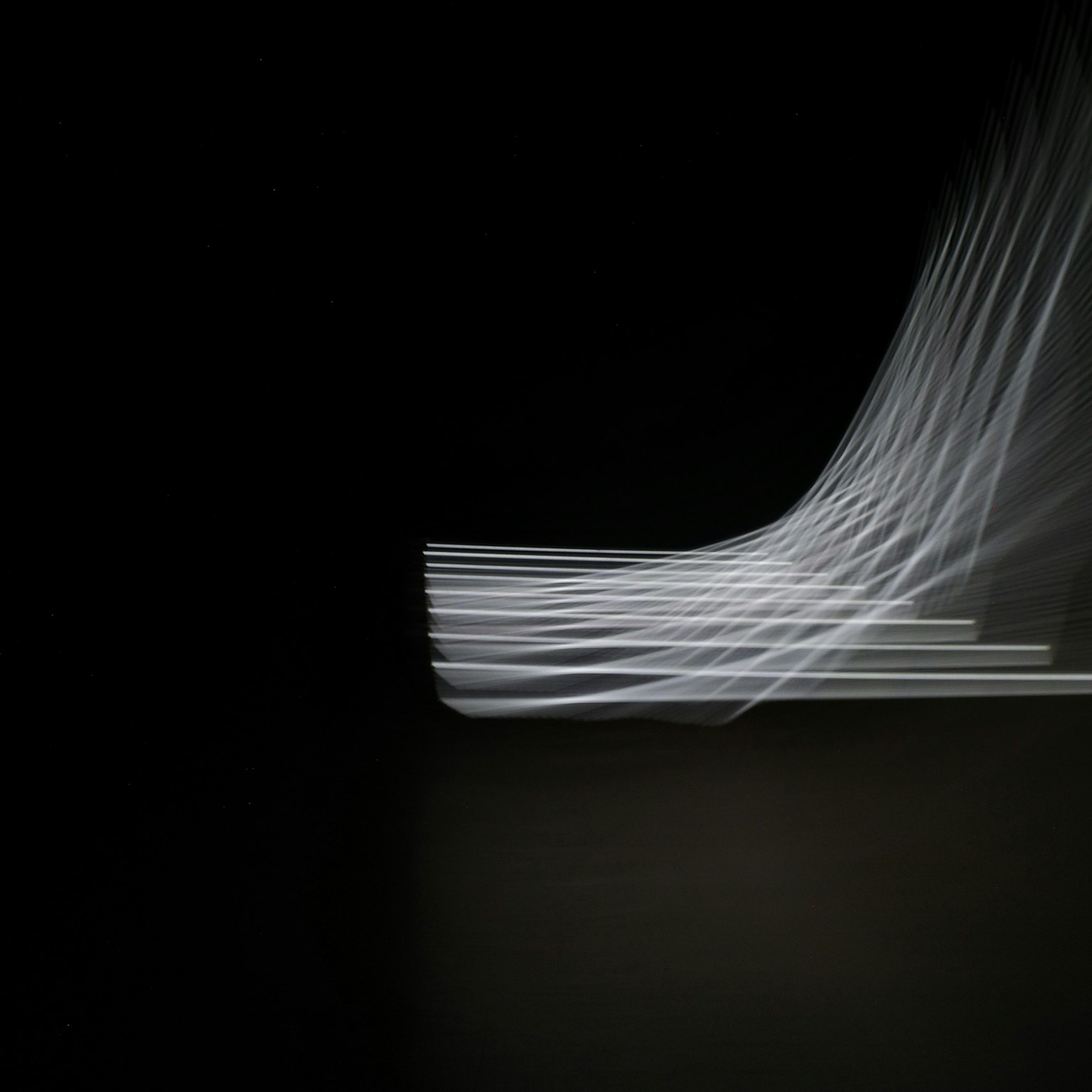 黑色背景上流動的白色光波的抽象圖像
