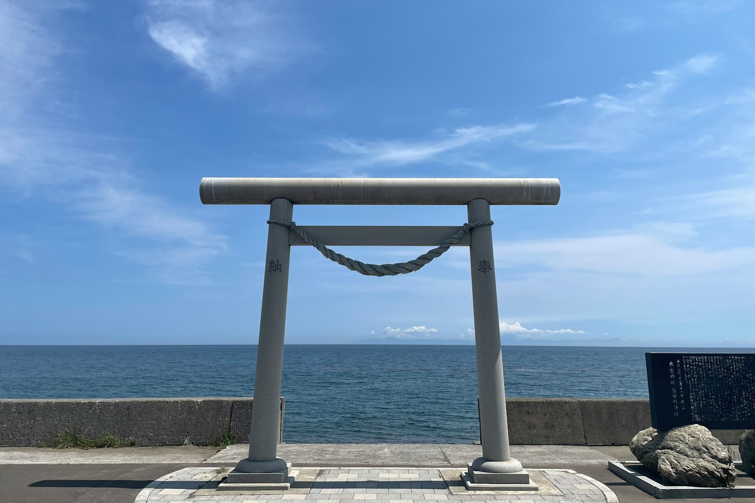 Portale bianco con corda contro cielo blu e oceano