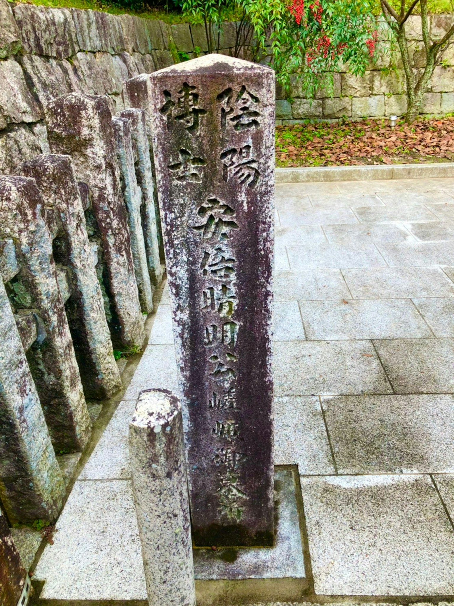 Monumento de piedra con texto grabado y paisaje de piedras circundantes