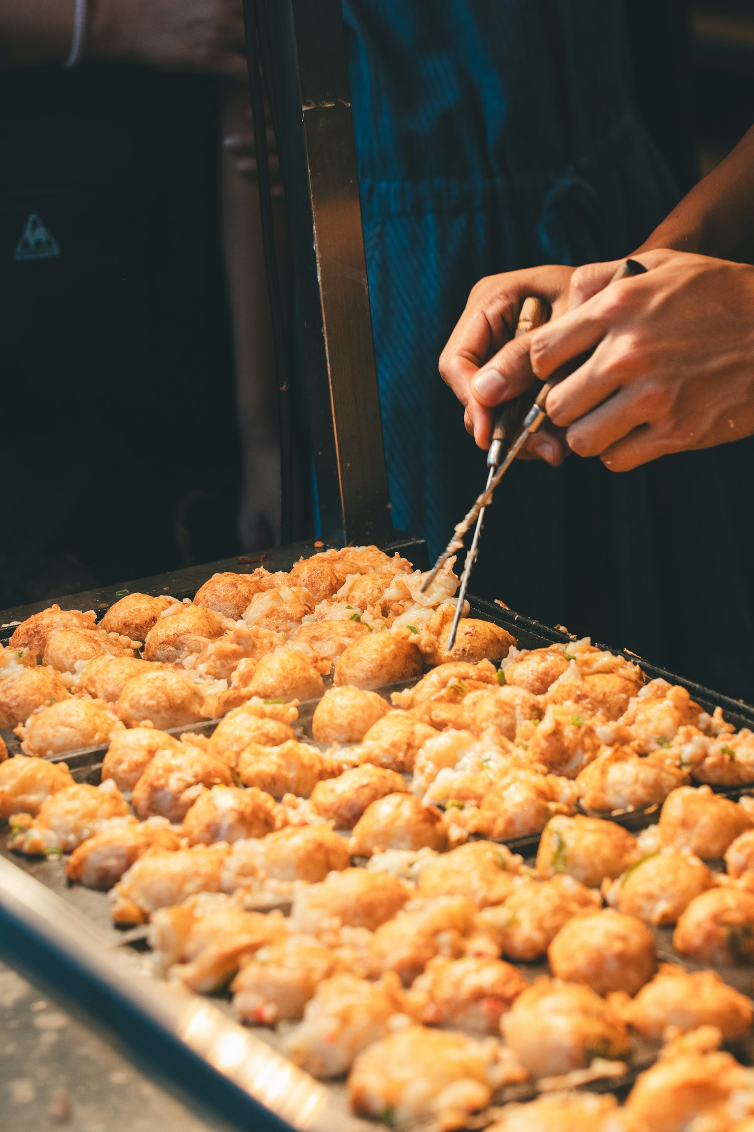 Mani che preparano cibo fritto su un vassoio