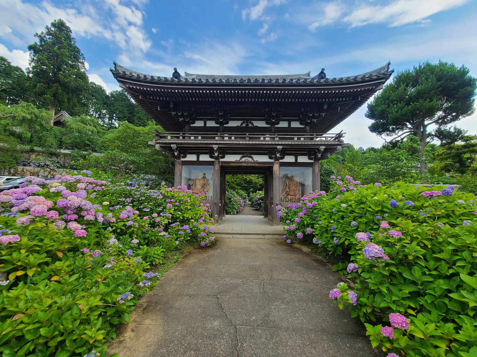 Pintu tradisional Jepang dikelilingi bunga yang cerah