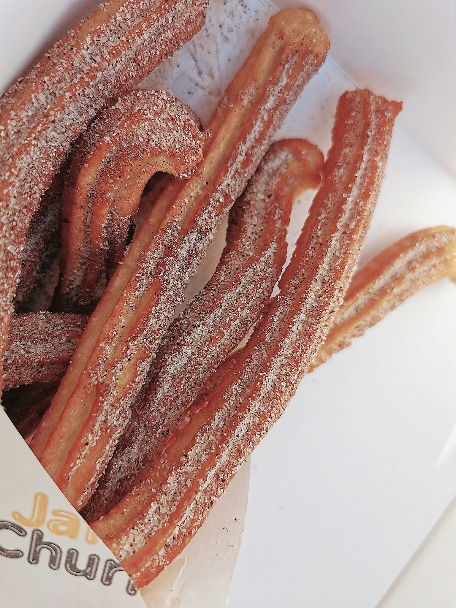 Un grupo de churros en una simple caja blanca
