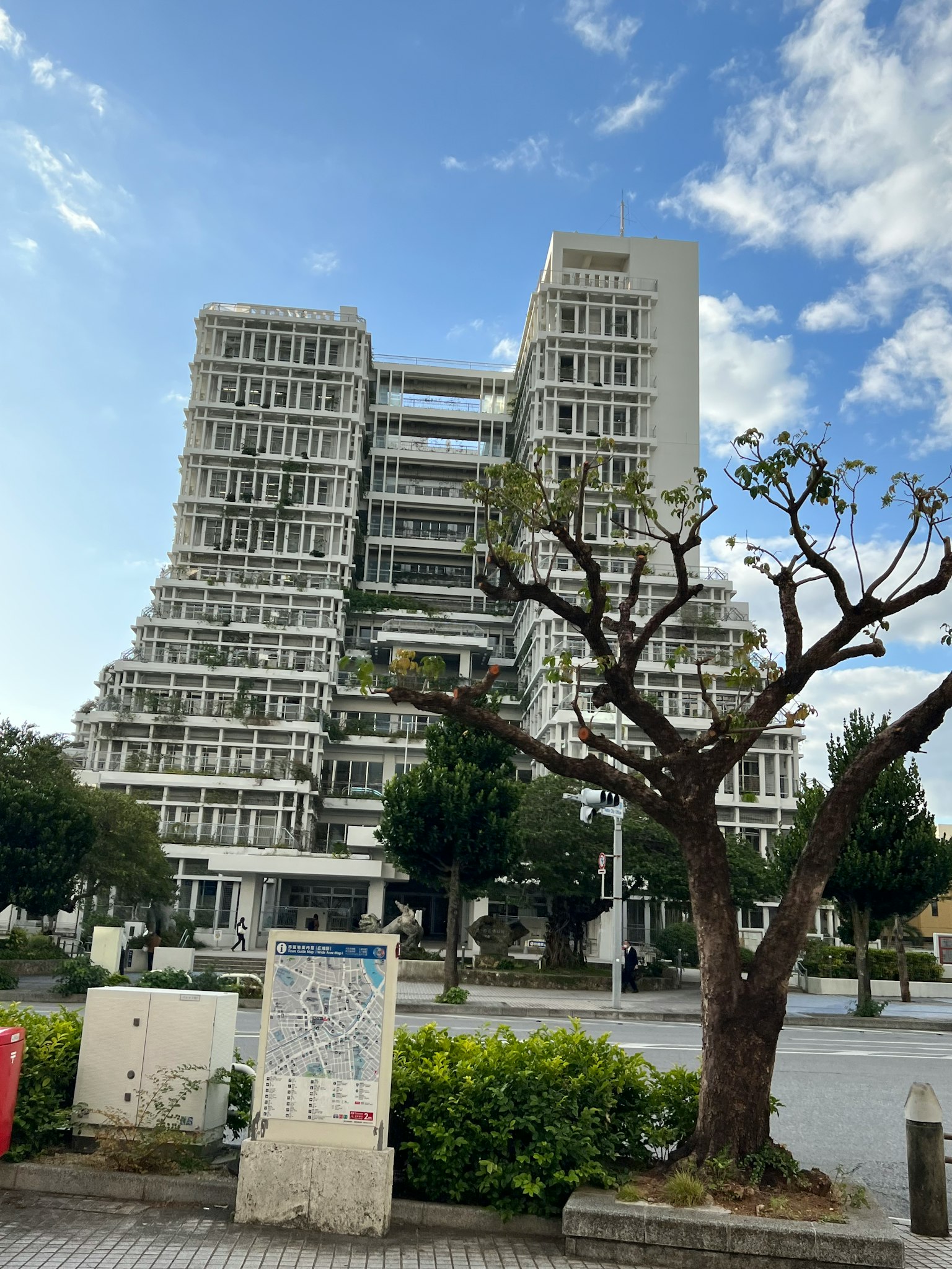 Unique designed high-rise building with trimmed trees in the streetscape