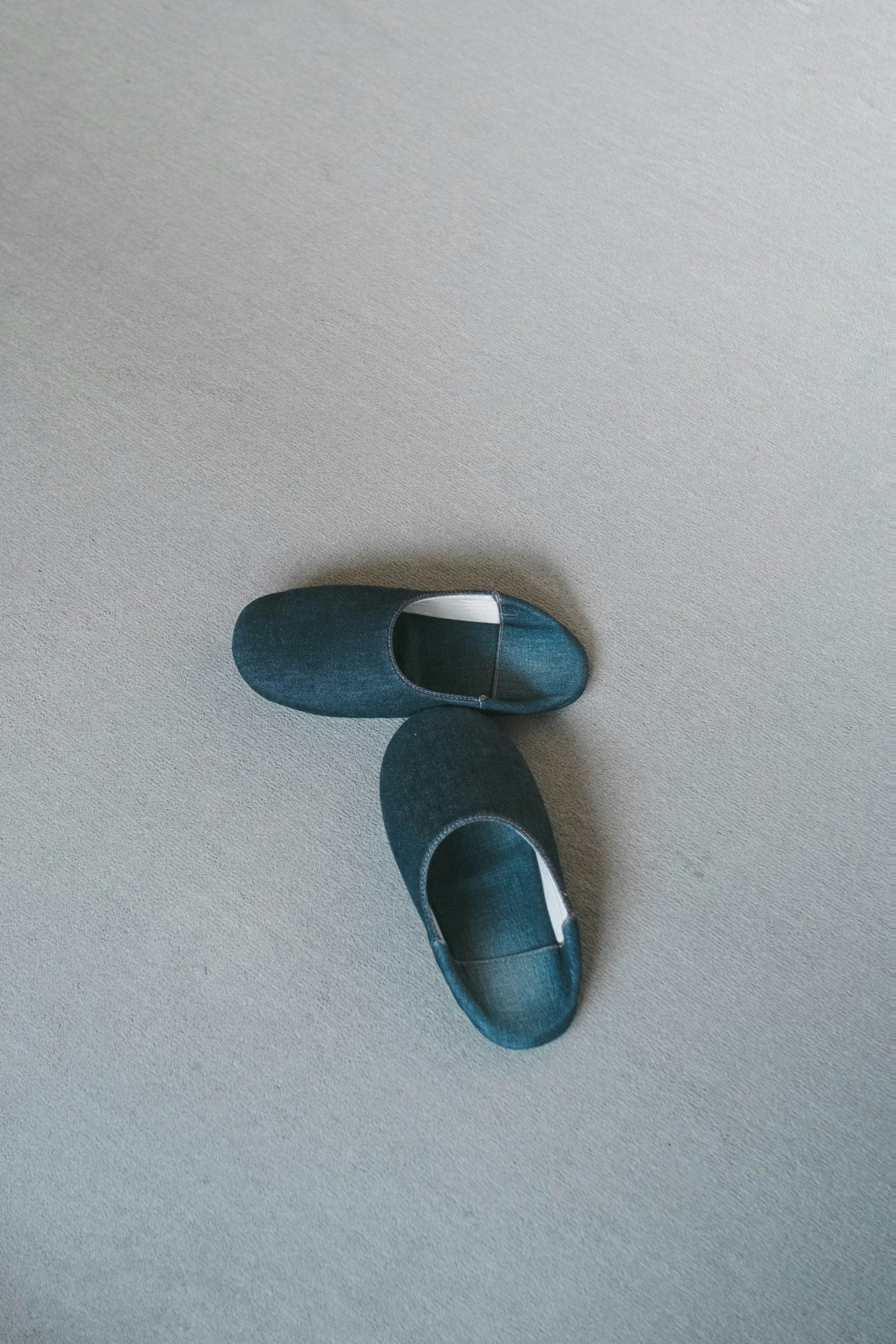 Black slippers placed on a gray floor