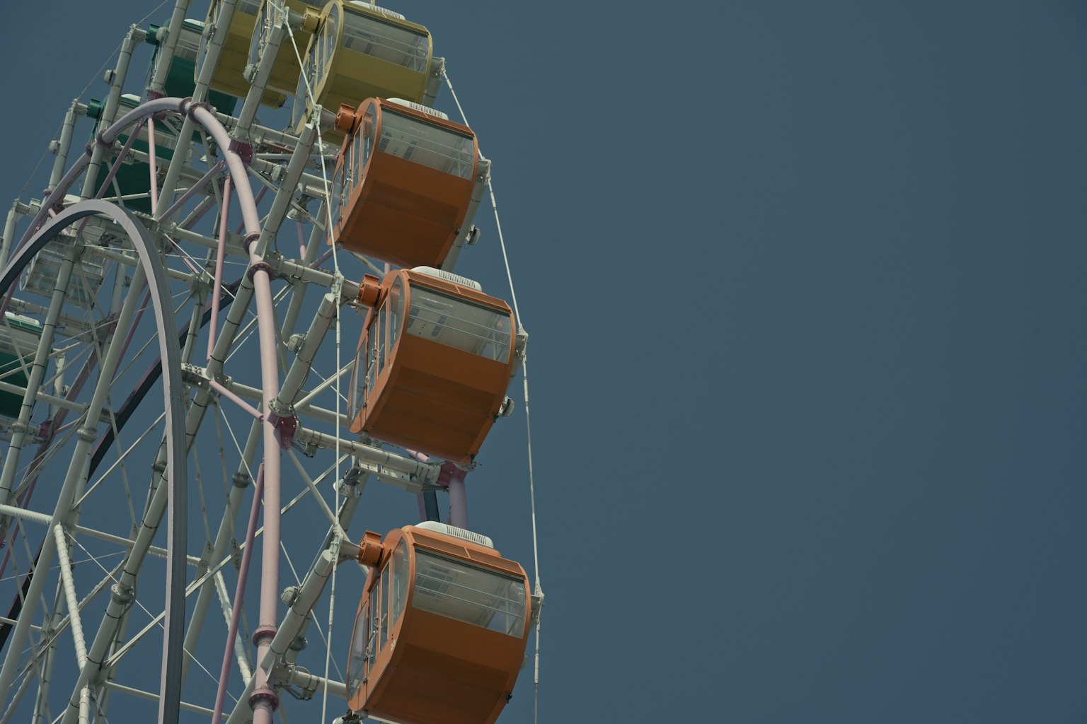 Ruota panoramica con cabine gialle e arancioni contro un cielo blu