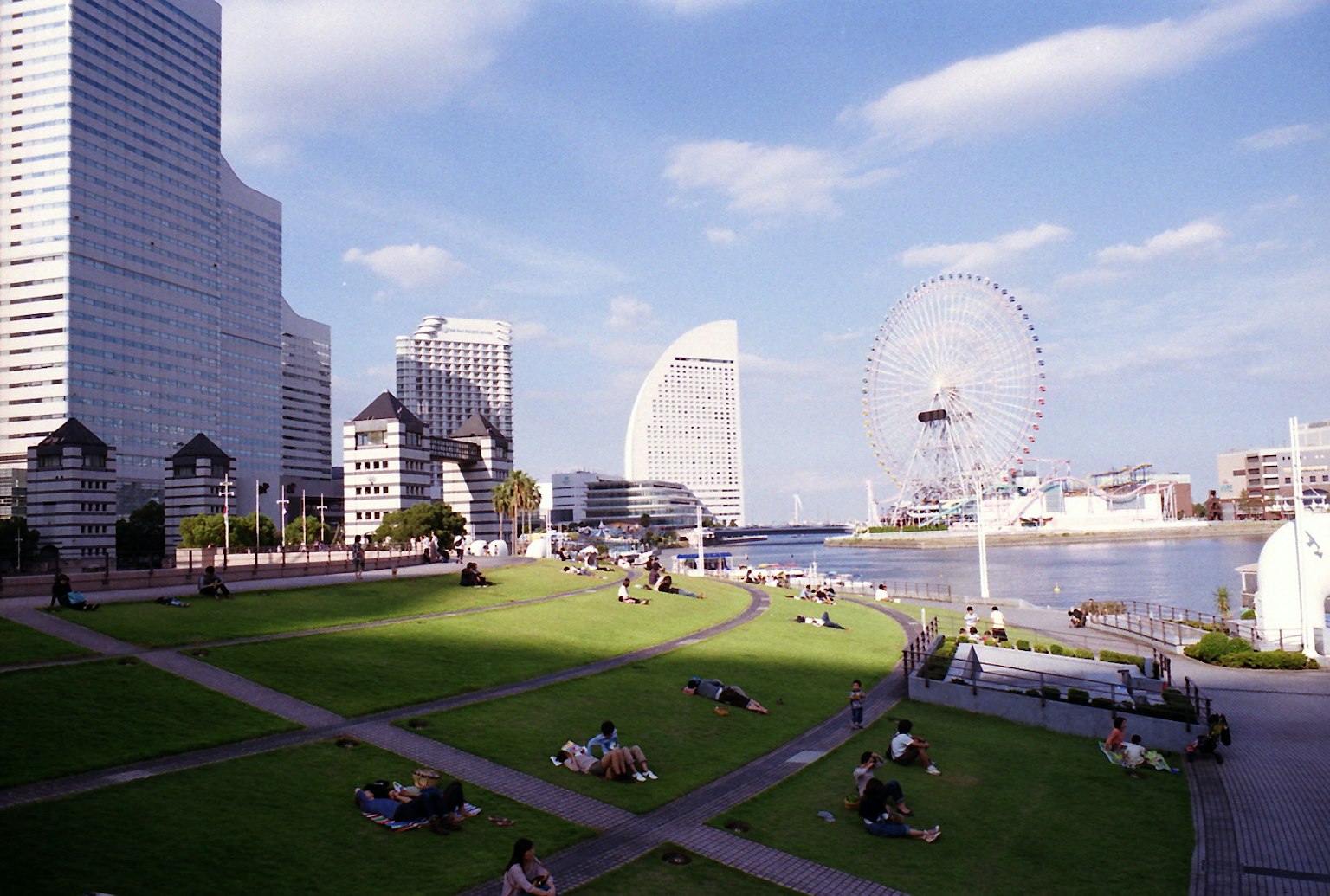 Uferpark in Yokohama mit entspannenden Menschen und einem Riesenrad