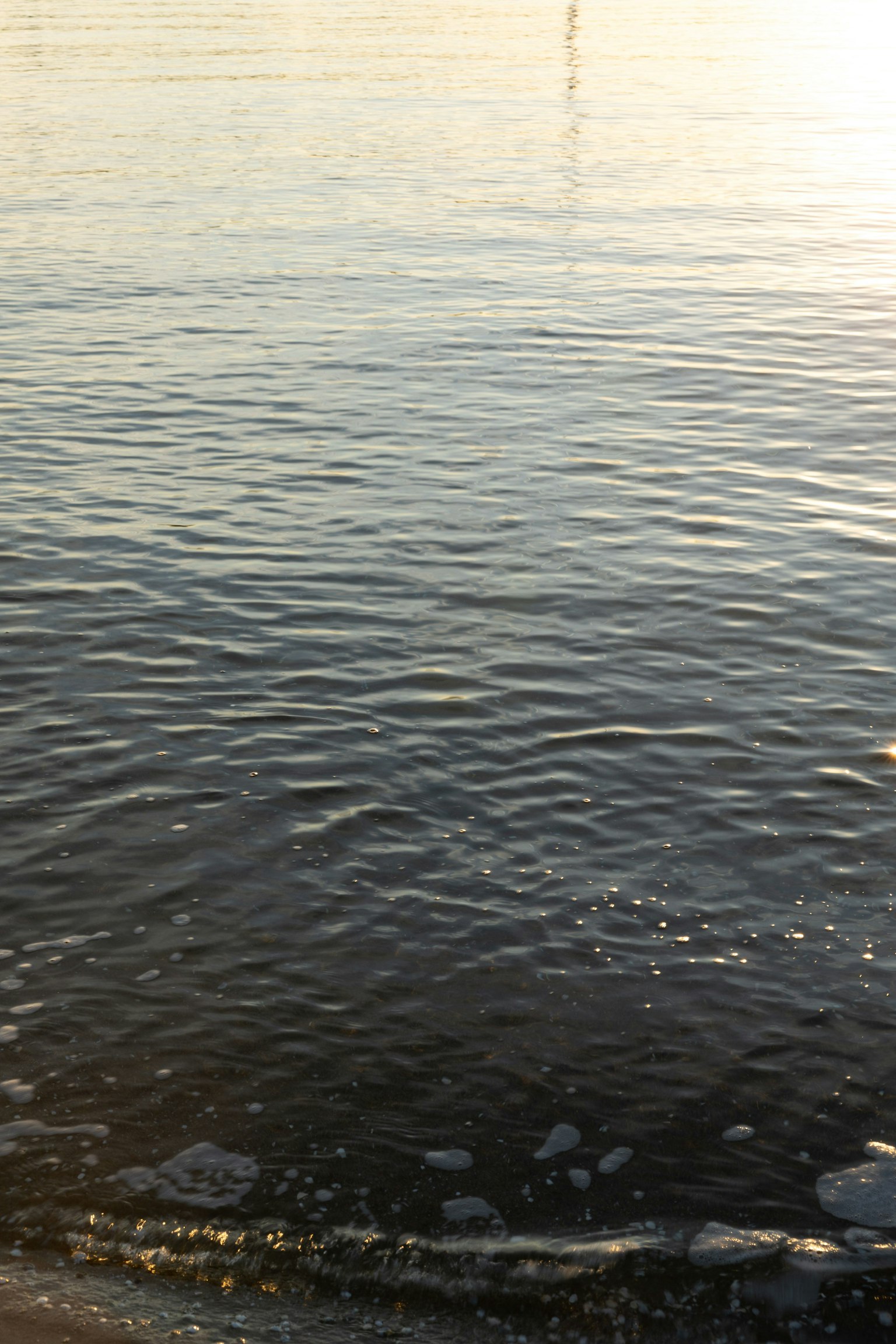Superficie de agua tranquila reflejando luz