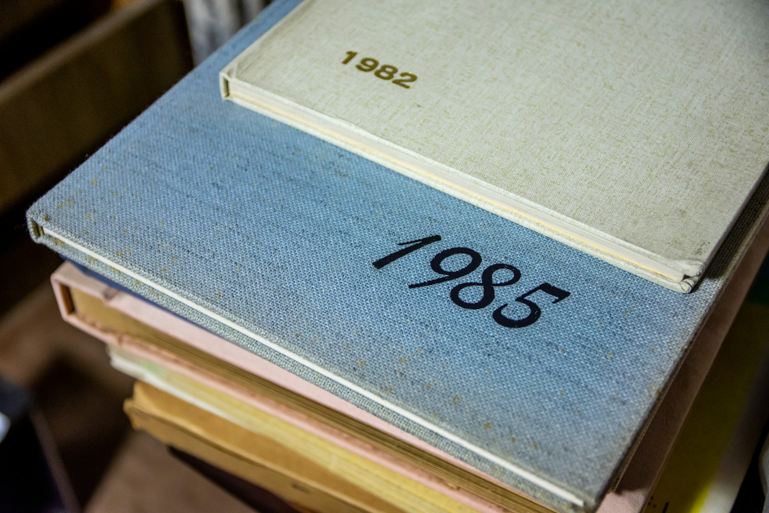Mucchio di libri colorati con un libro etichettato 1985 in cima