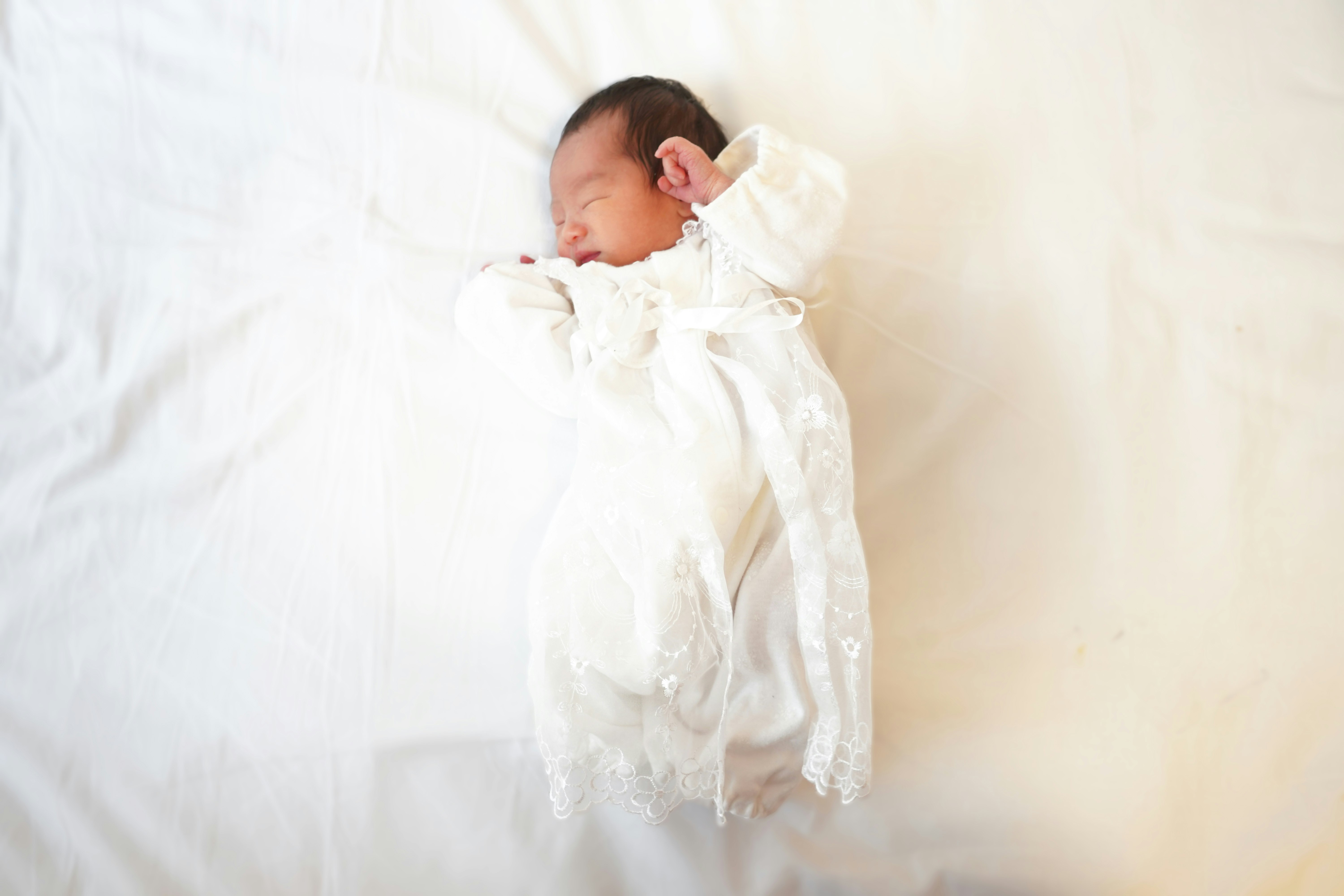 白色毯子上的熟睡嬰兒