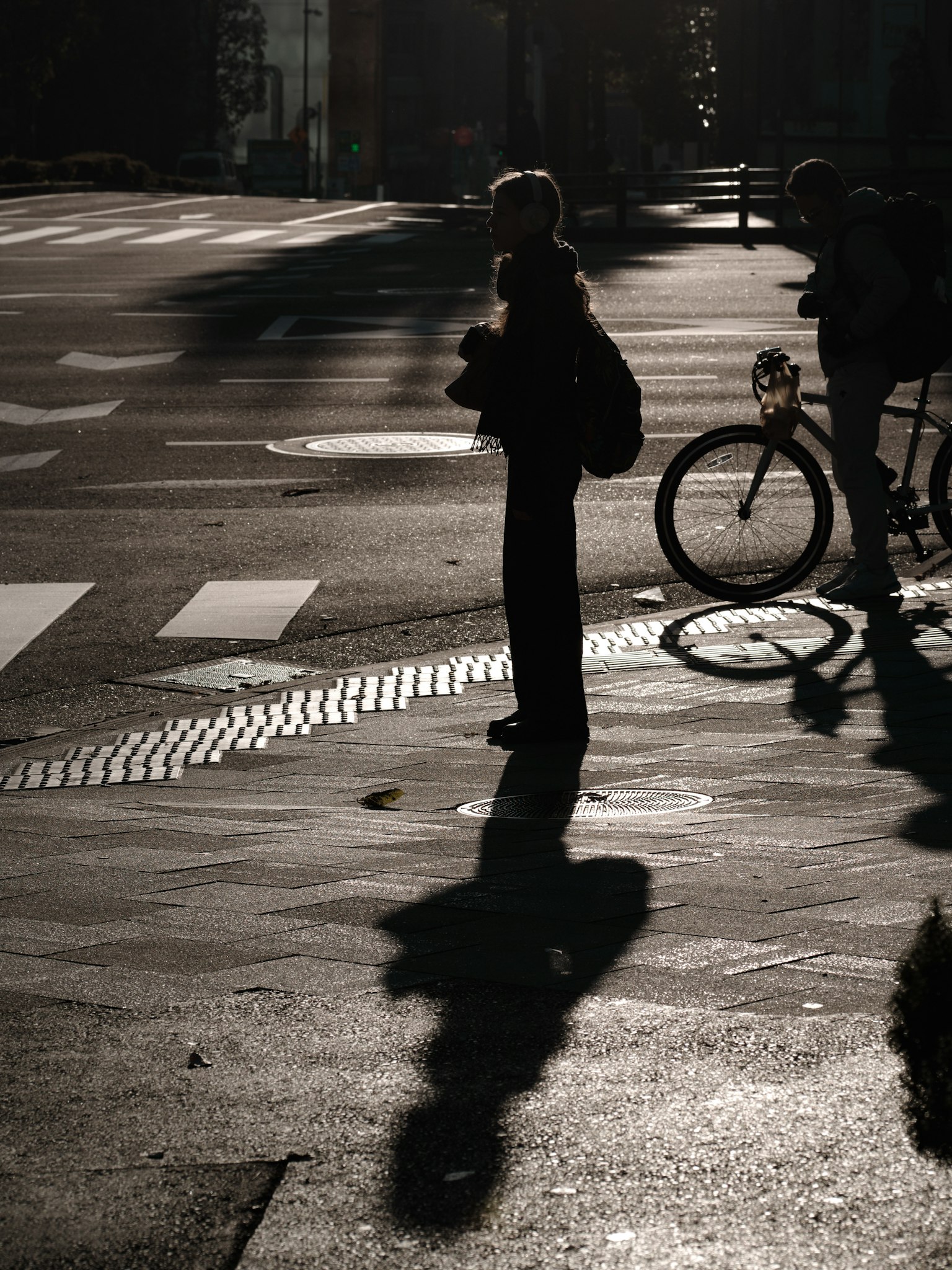 Silueta de una persona y una bicicleta en una escena de calle
