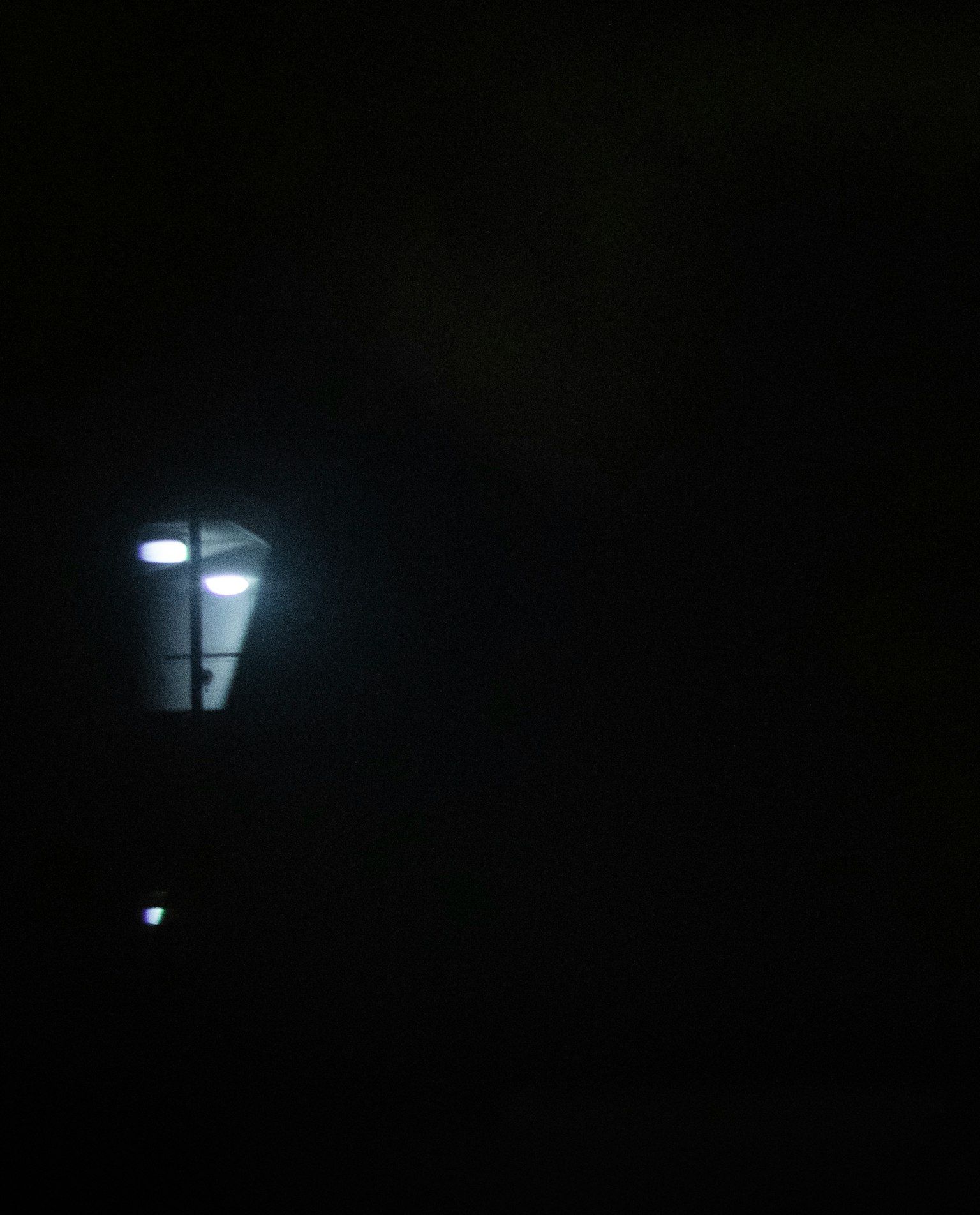 Farola brillando en la oscuridad con un fondo tenue