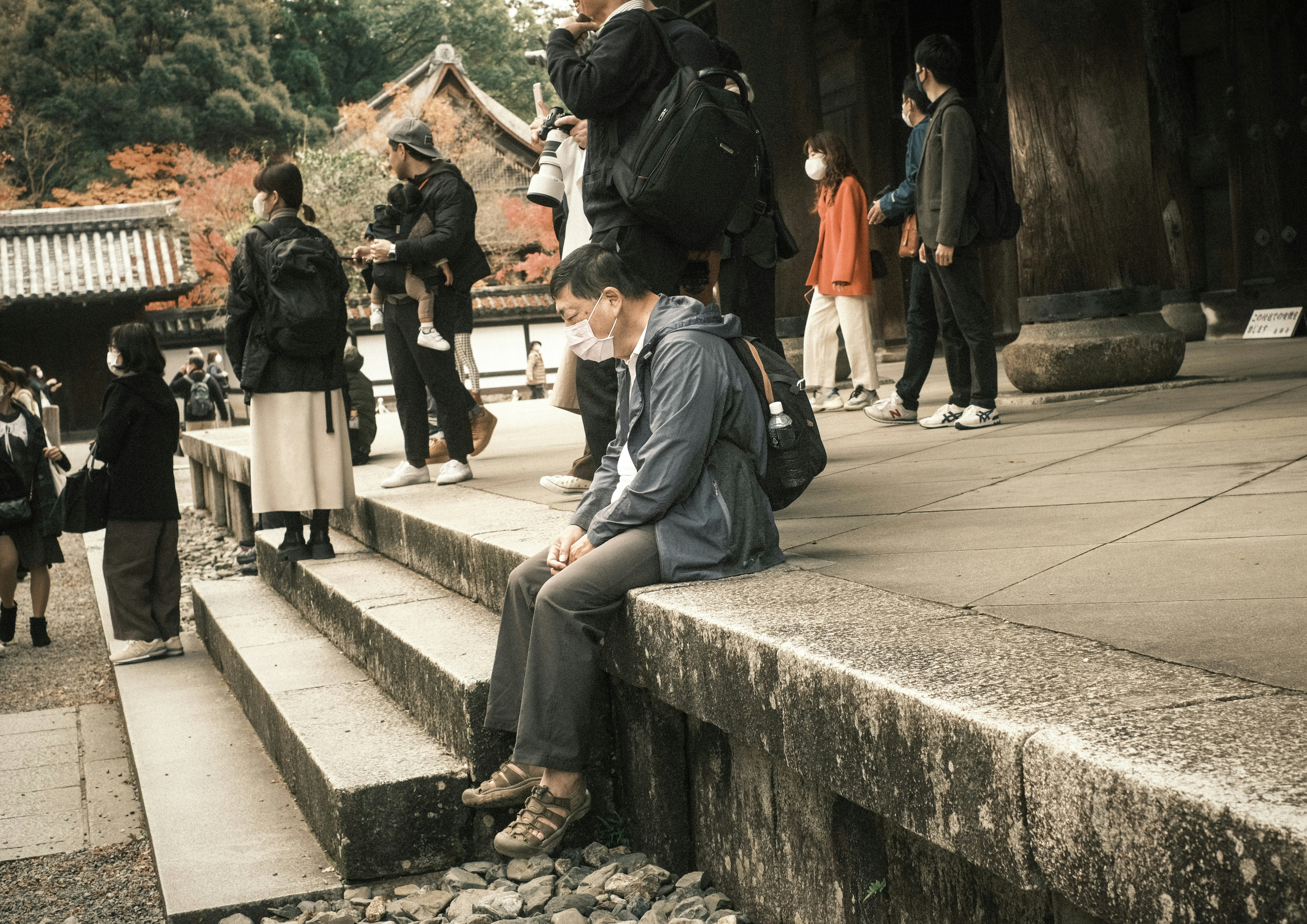 tourists and visitors sitting on stone steps in a temple courtyard