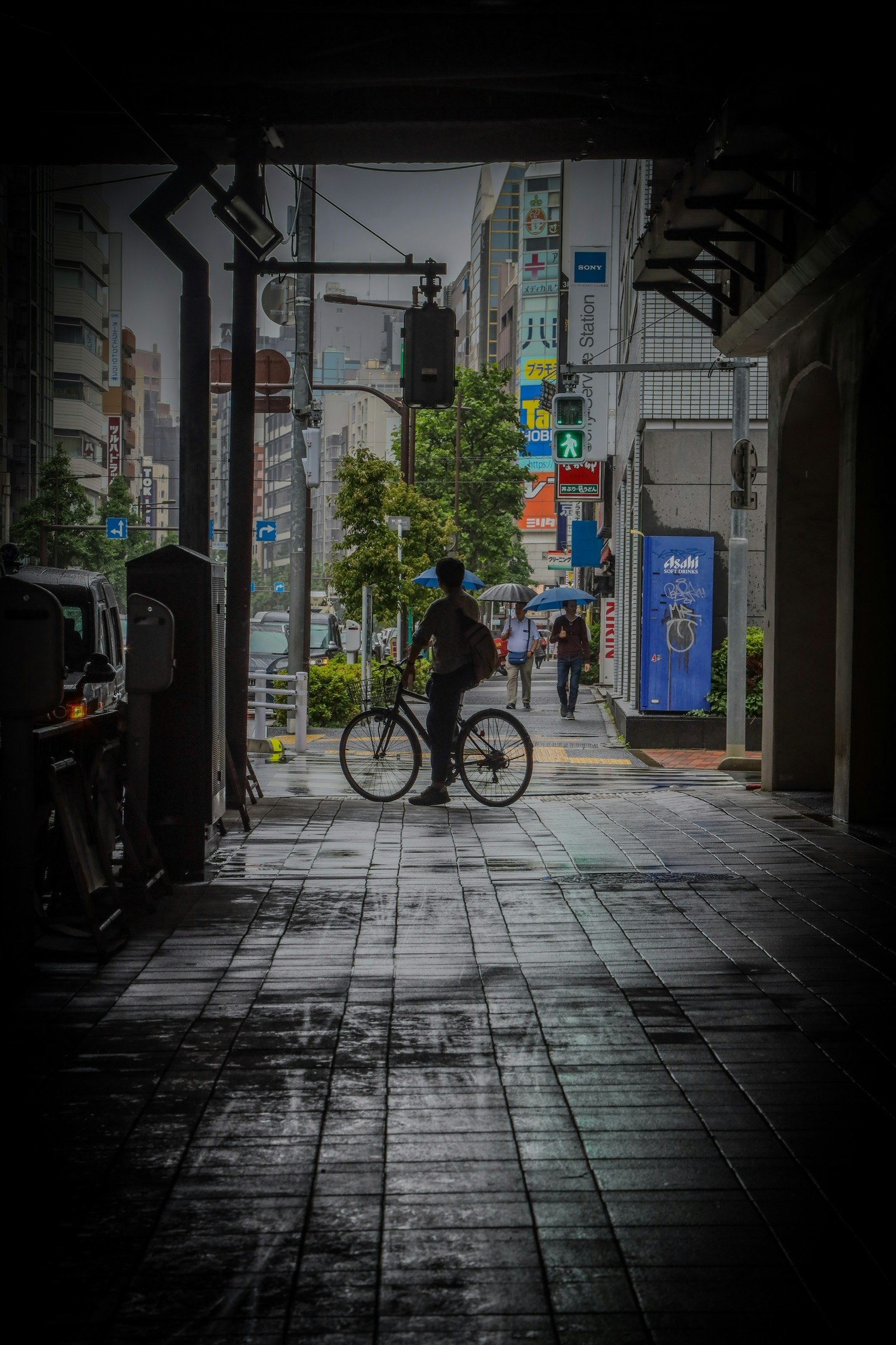 雨上がりの路地で自転車が並ぶ商店街の軒先
