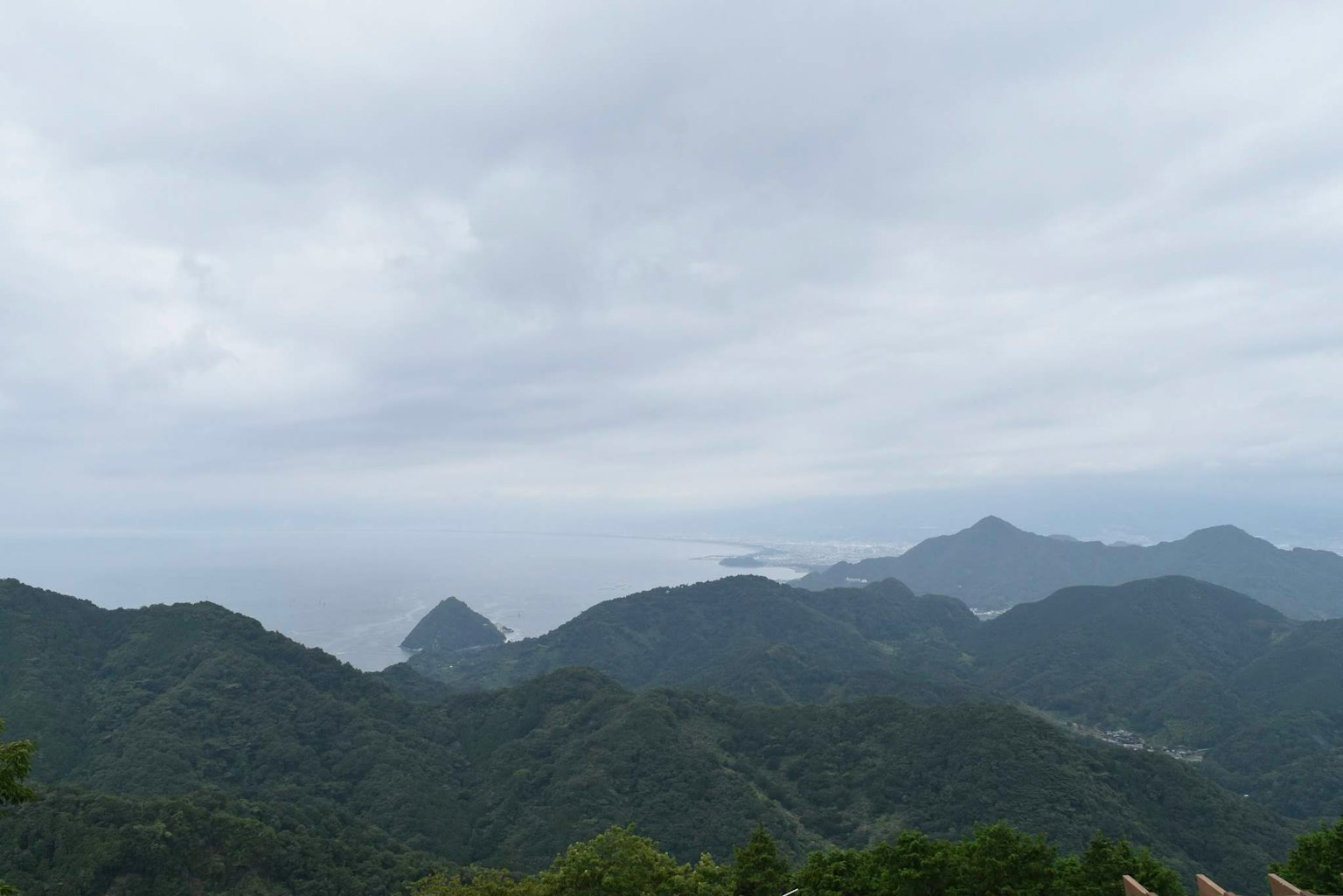 Vue panoramique des montagnes et de l'océan sous un ciel nuageux