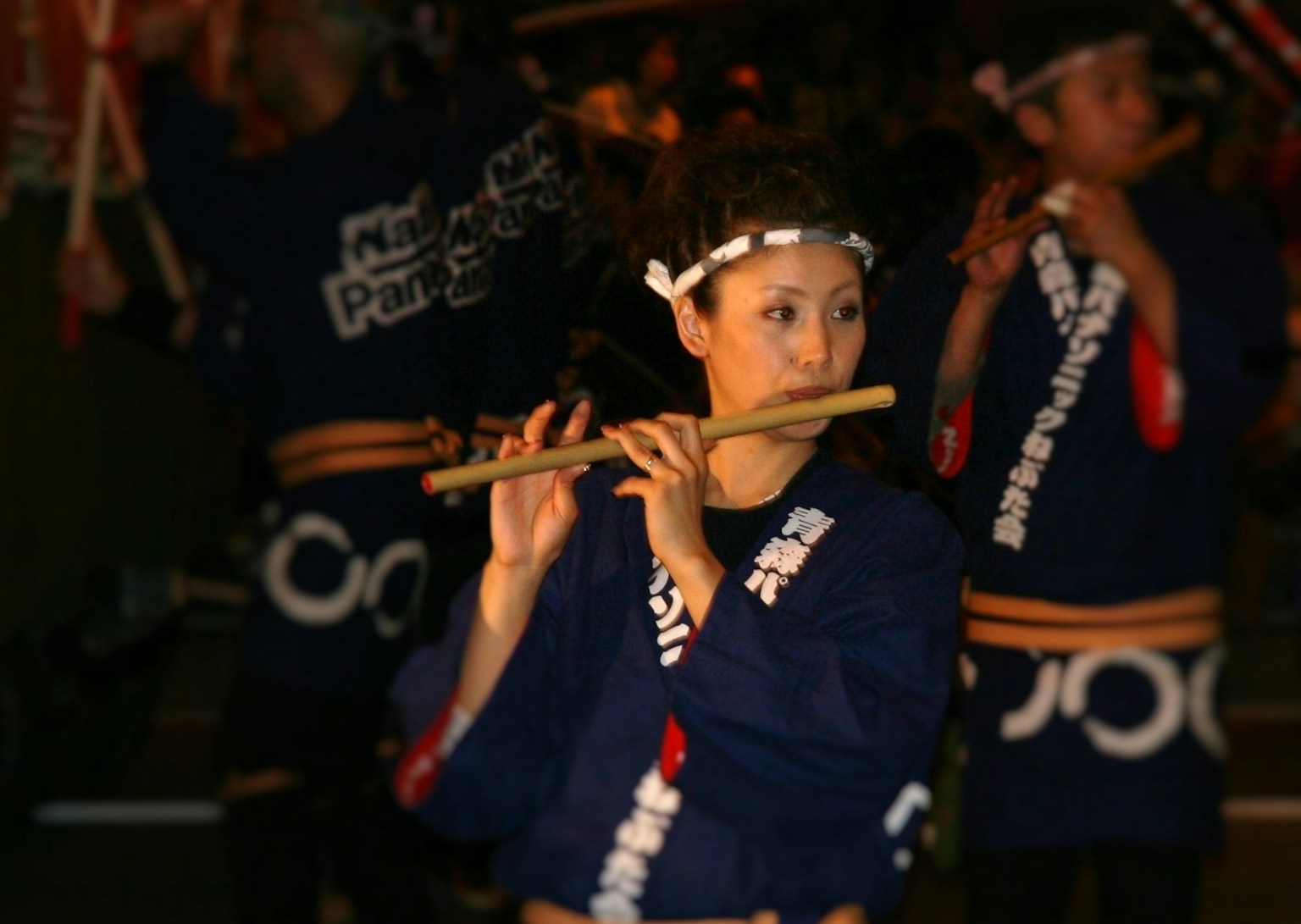 Woman playing a flute in traditional attire during a performance