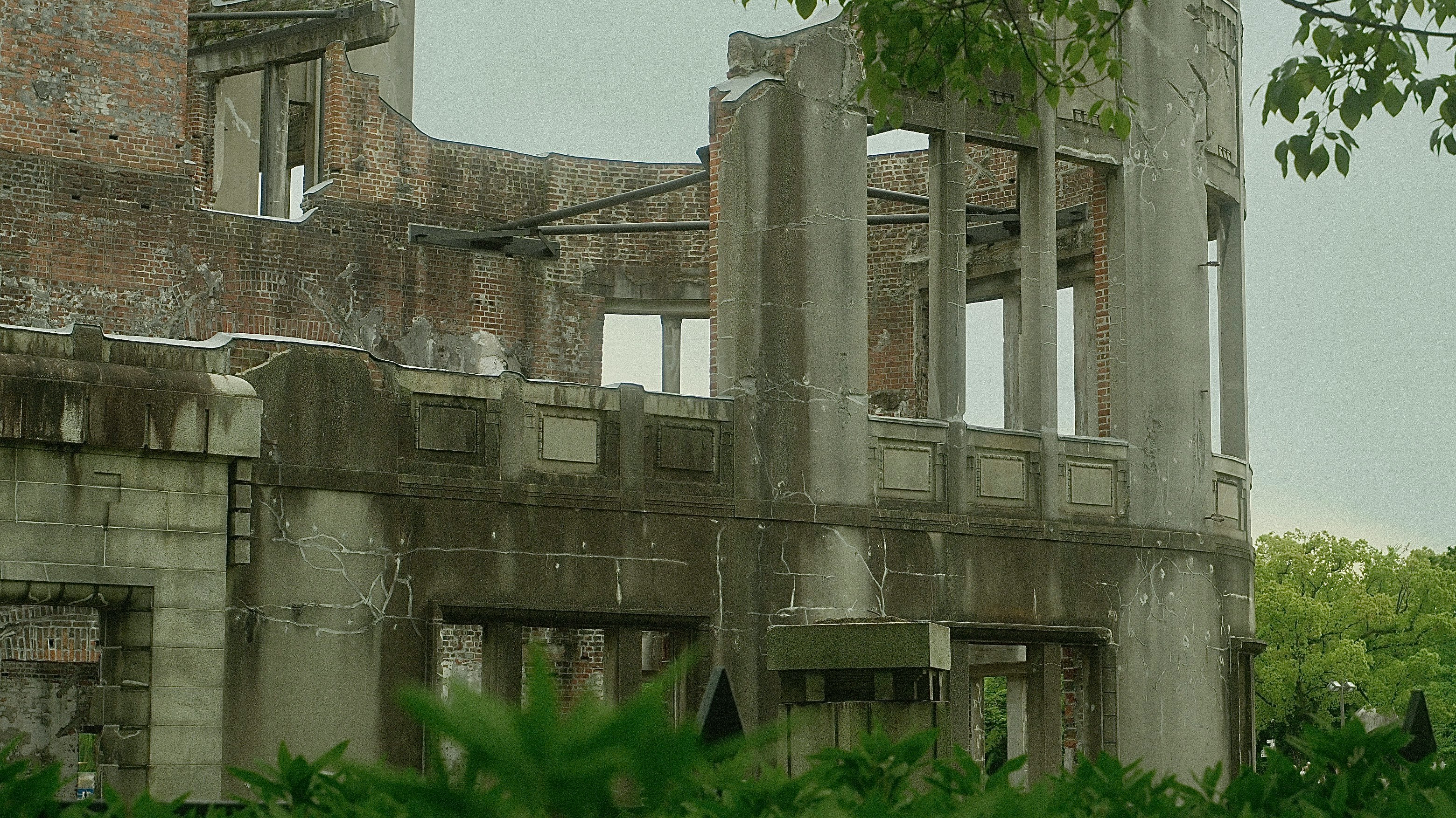 廃墟のレンガ建物とコンクリートの柱が並ぶ中庭の風景
