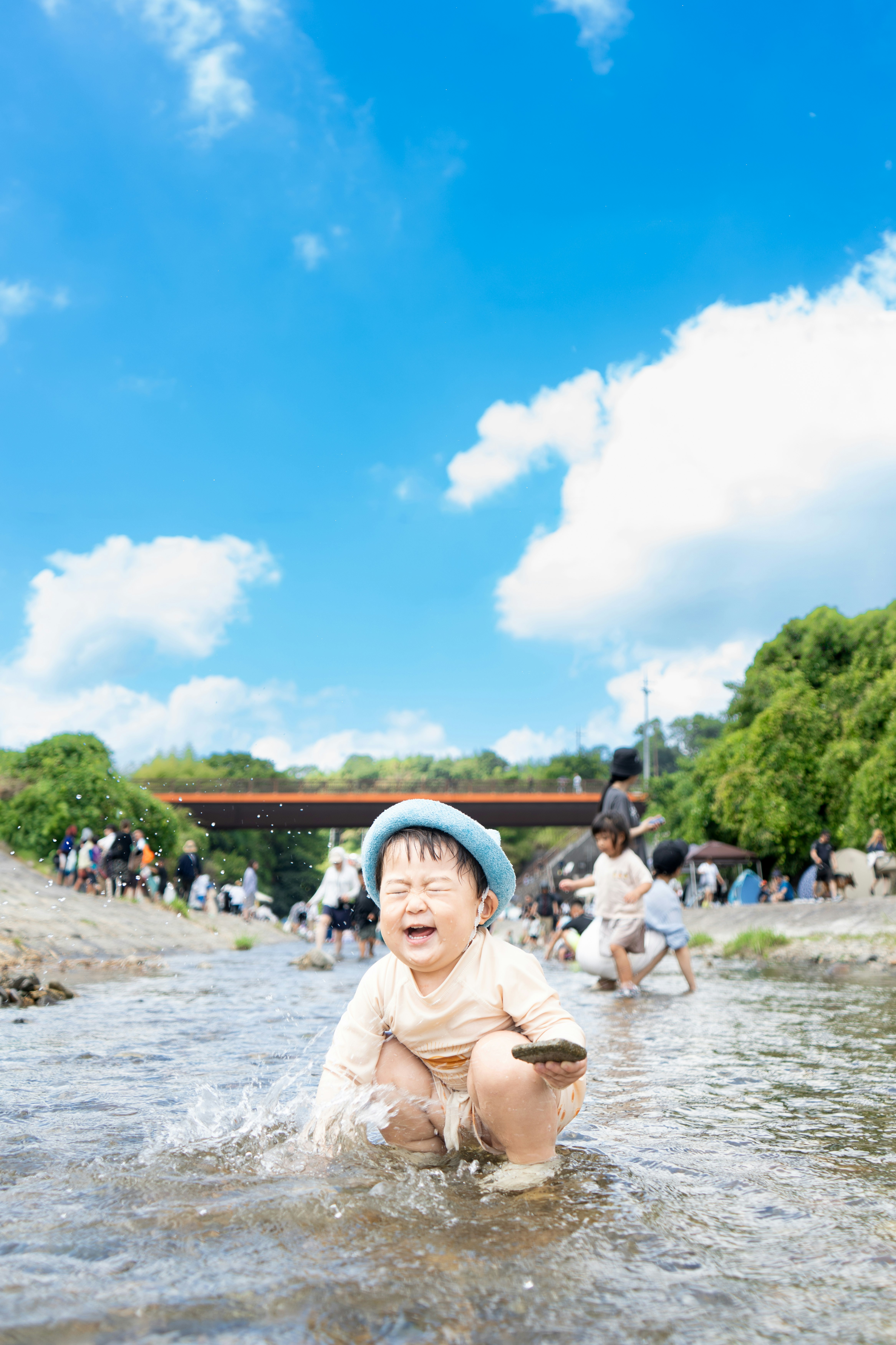 川遊びをする人と水しぶきのある川辺の風景