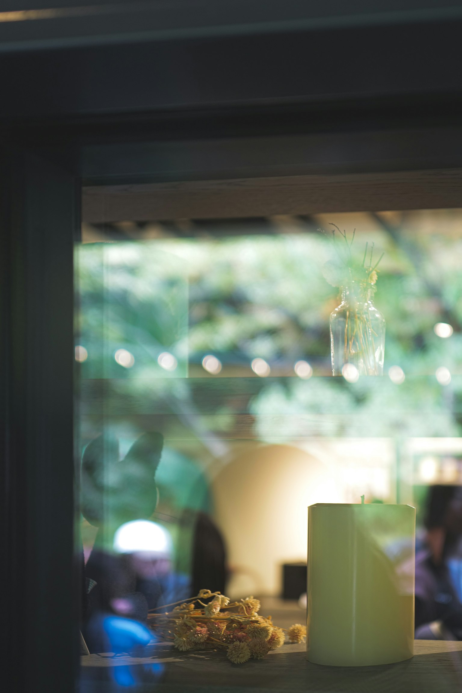 窓の外に緑の背景が見えるキャンドルとポップコーンのあるシーン