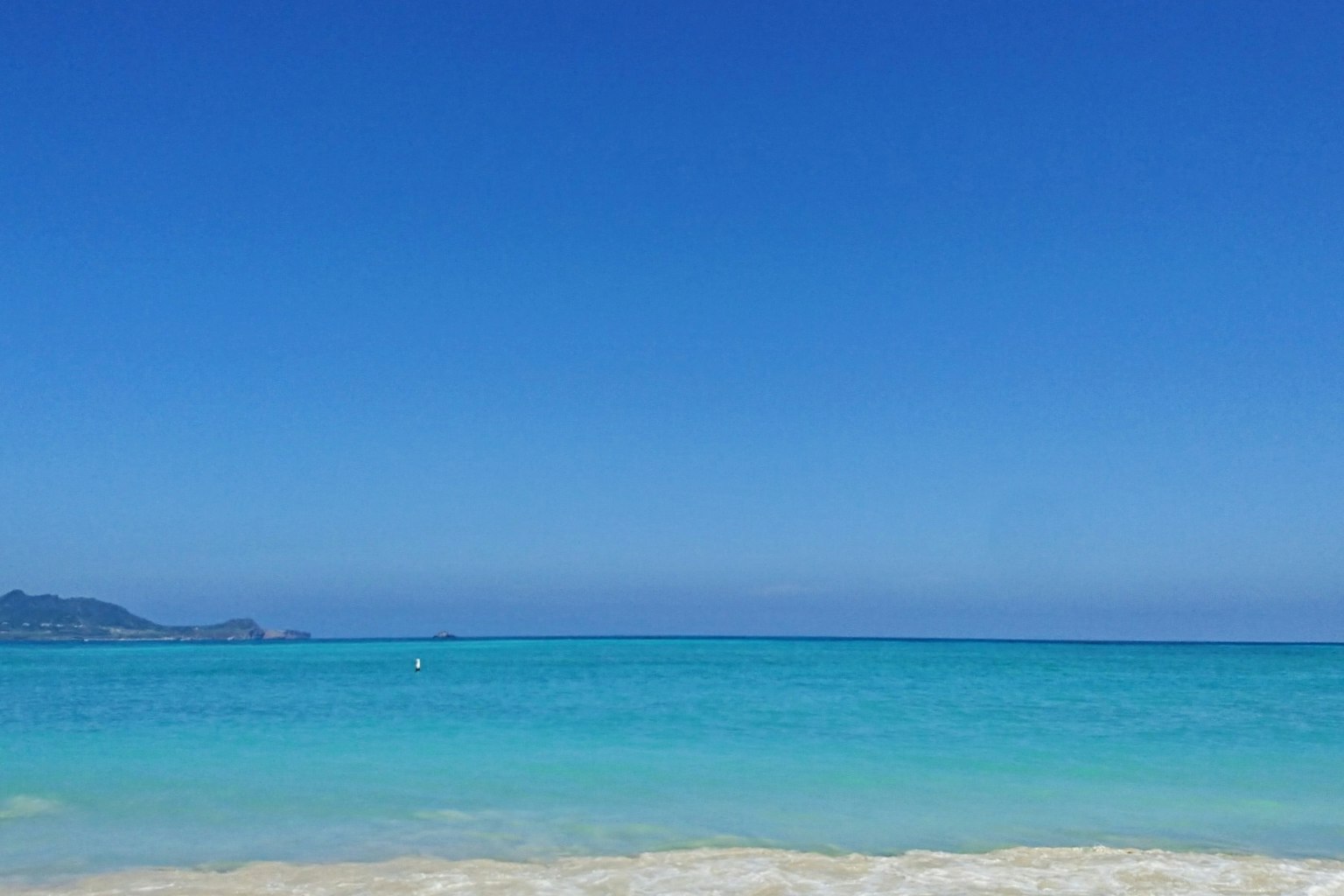 Escena de playa con océano azul y cielo claro