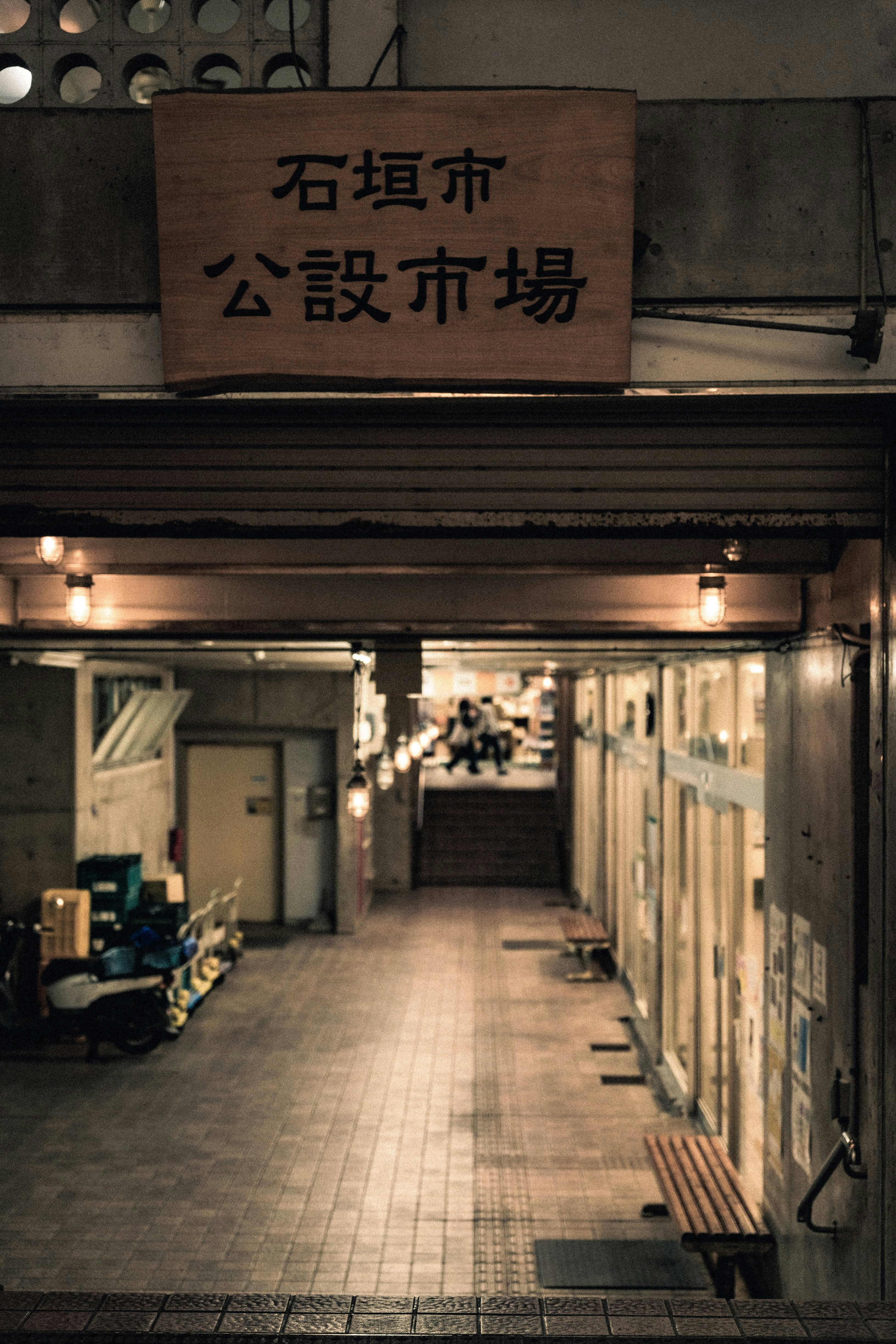石垣市公設市場通道，兩側店鋪與暖色燈光