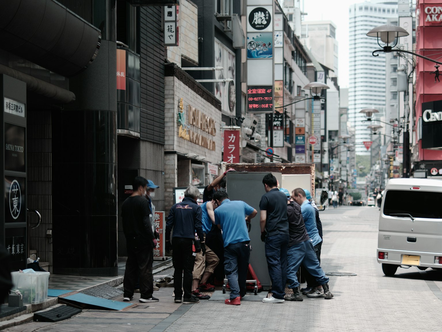 Gruppo di lavoratori in uniformi blu che collaborano a un compito in una strada della città
