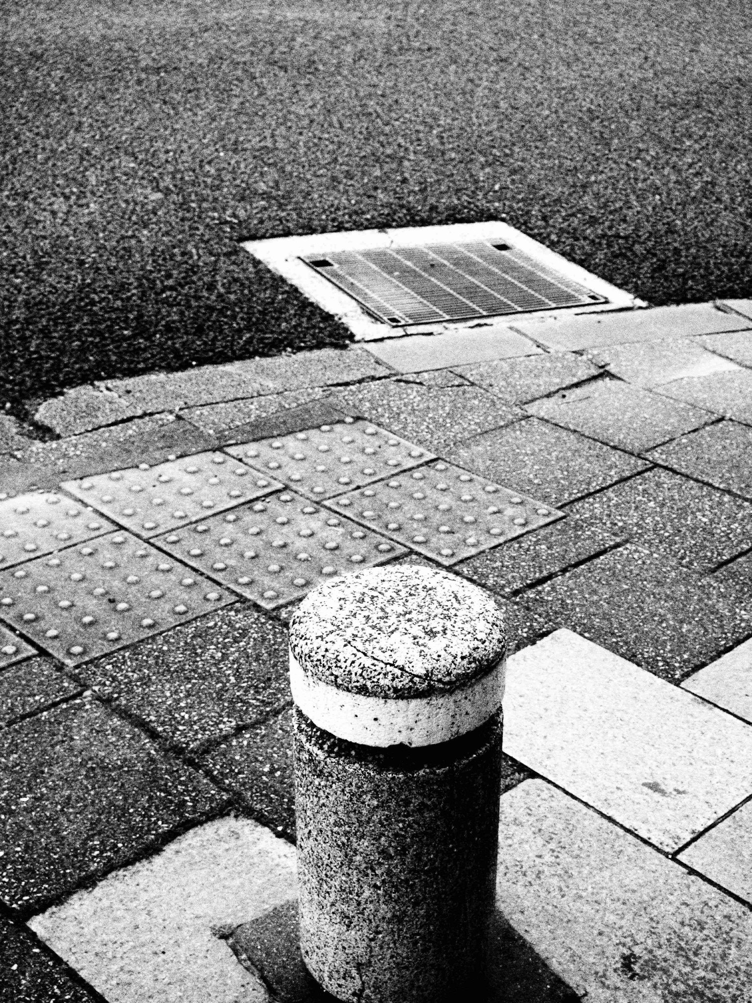 Bola de concreto en una acera de la ciudad con pavimento gris