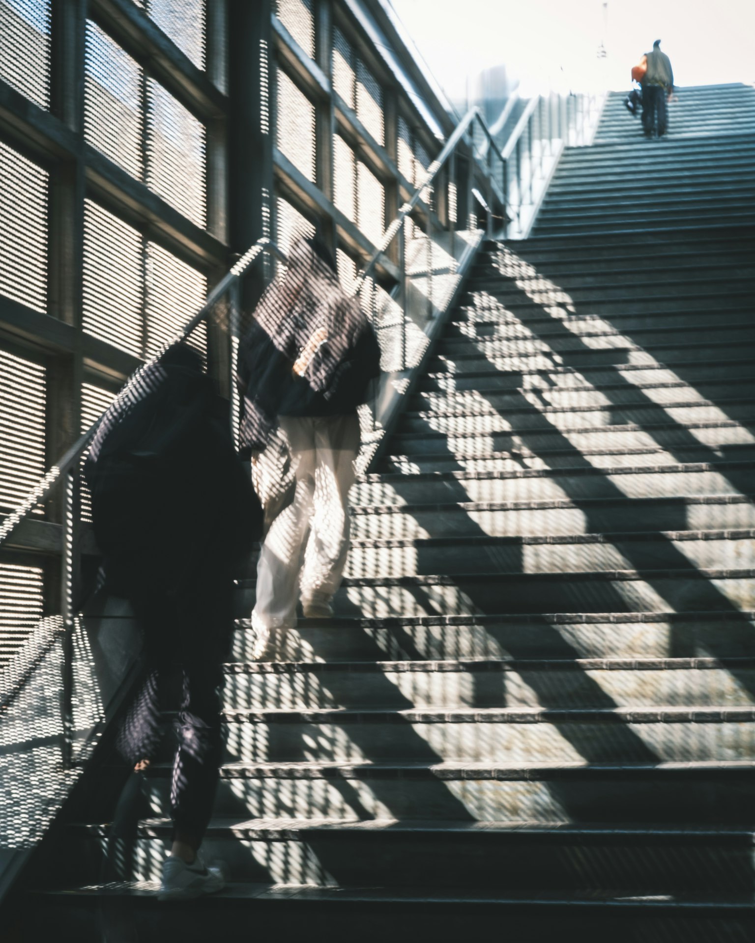 Eine Person, die Treppen hinaufsteigt, mit auffälligen Schatten und Lichtmustern