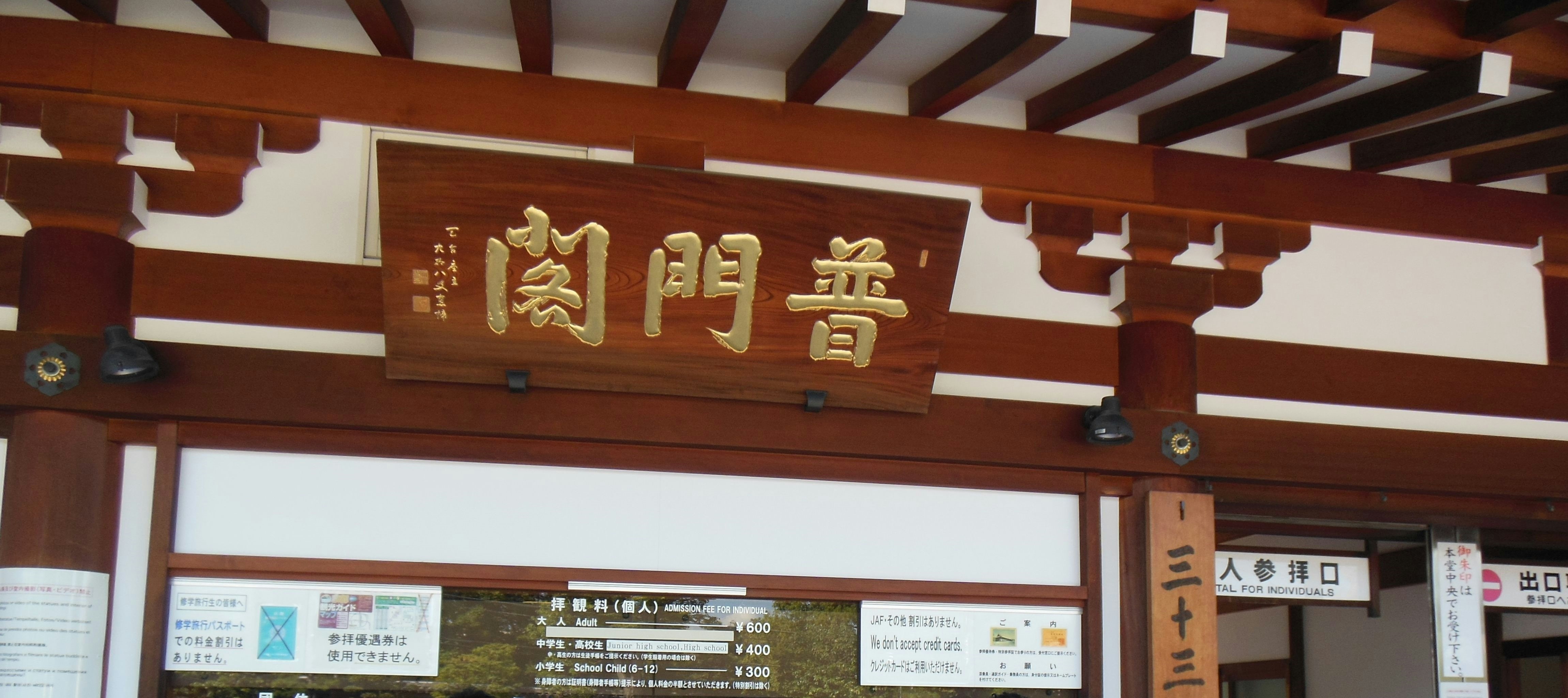門に掲げられた金色の看板と木造の入口