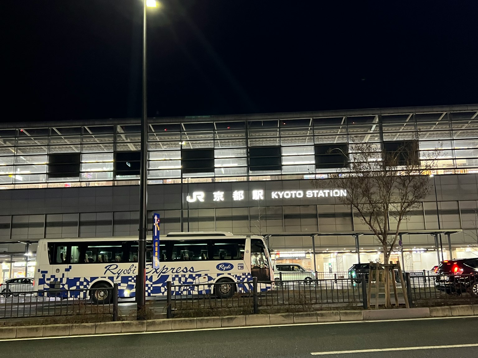 Vista esterna della stazione di Kyoto di notte con un autobus