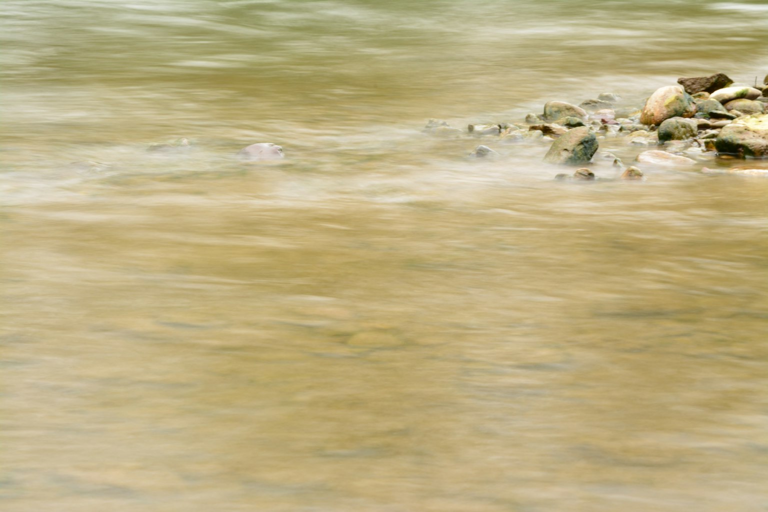 Flowing water with visible stones in a tranquil setting