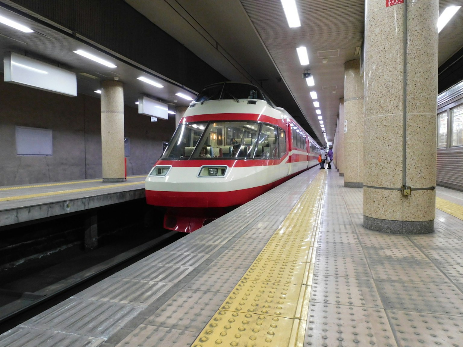 รถไฟสีแดงและขาวจอดอยู่ที่ชานชาลาสถานี