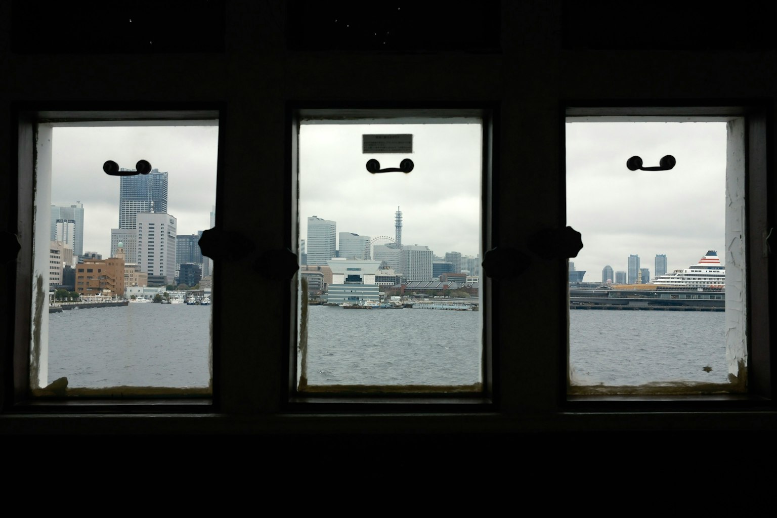 三つの窓から見える都市の景色と水面の反射