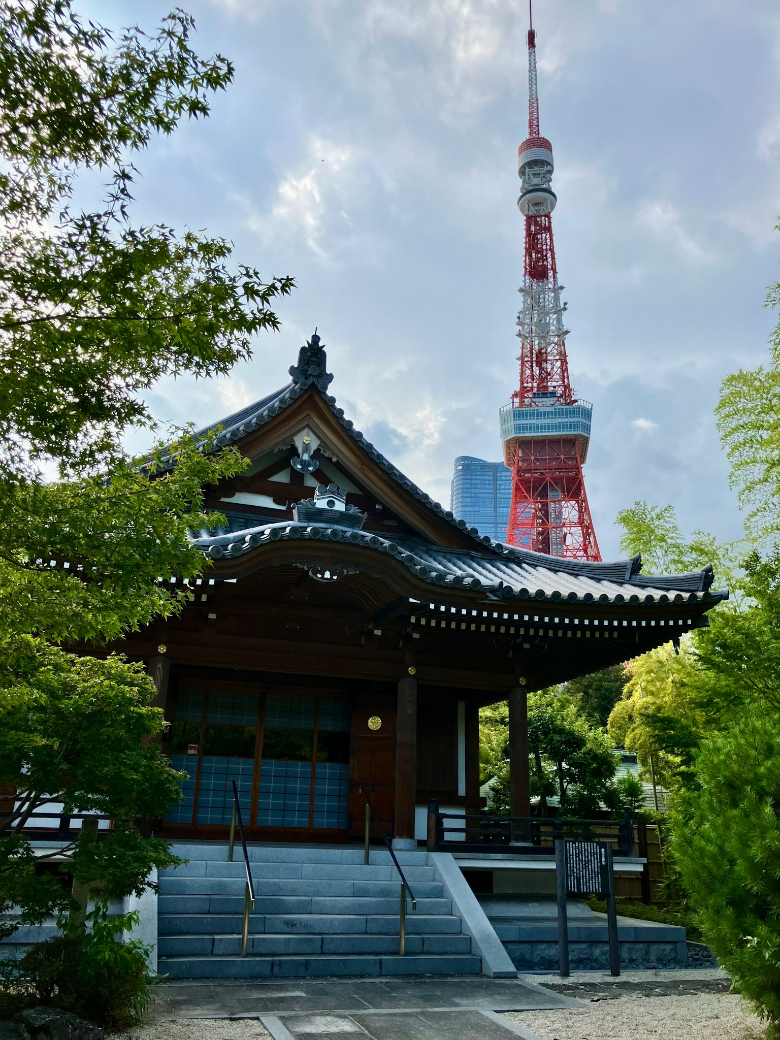 東京塔與傳統寺廟的對比 被綠色植物環繞