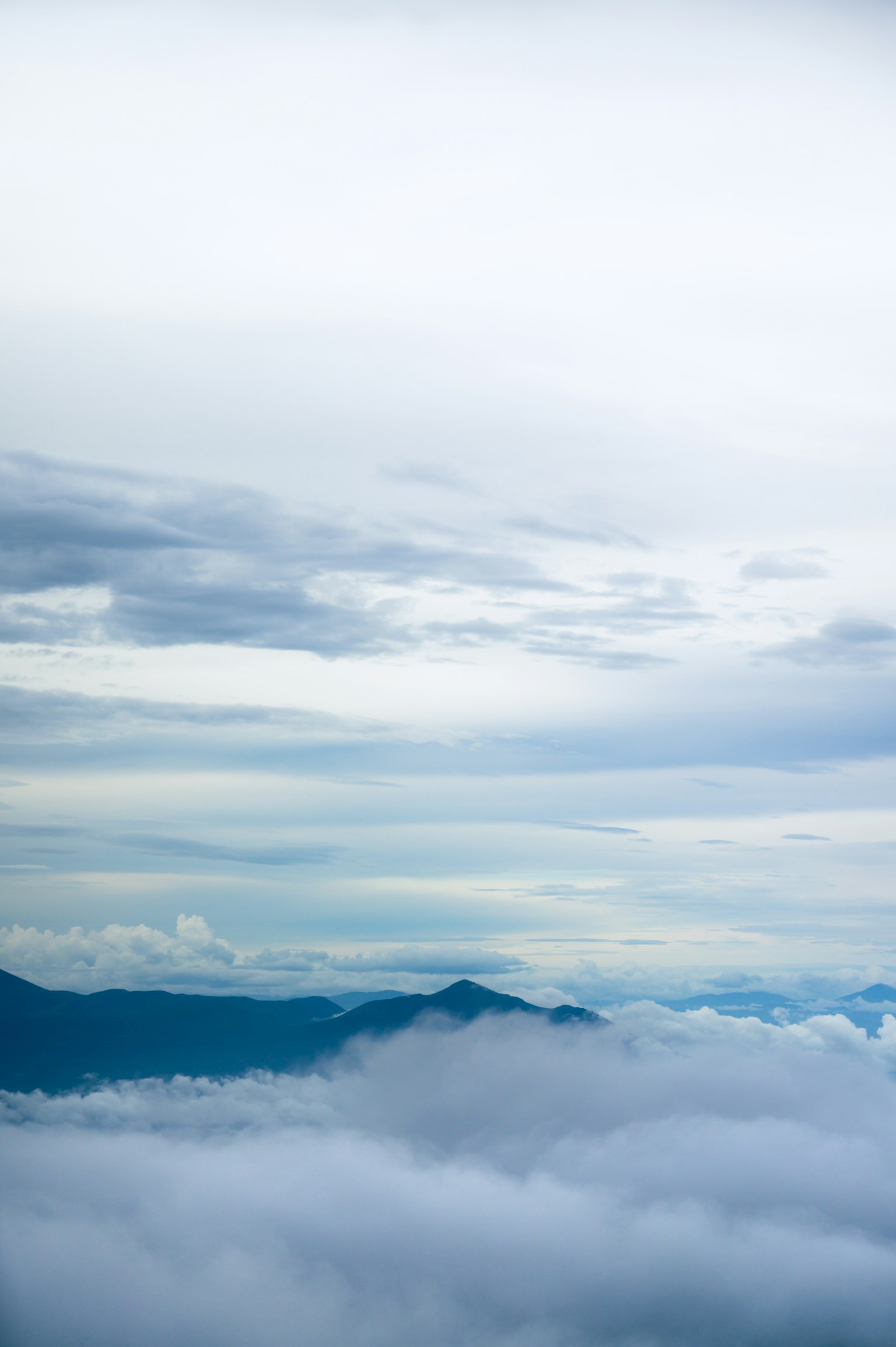 Montañas azules con un mar de nubes y cielo amplio
