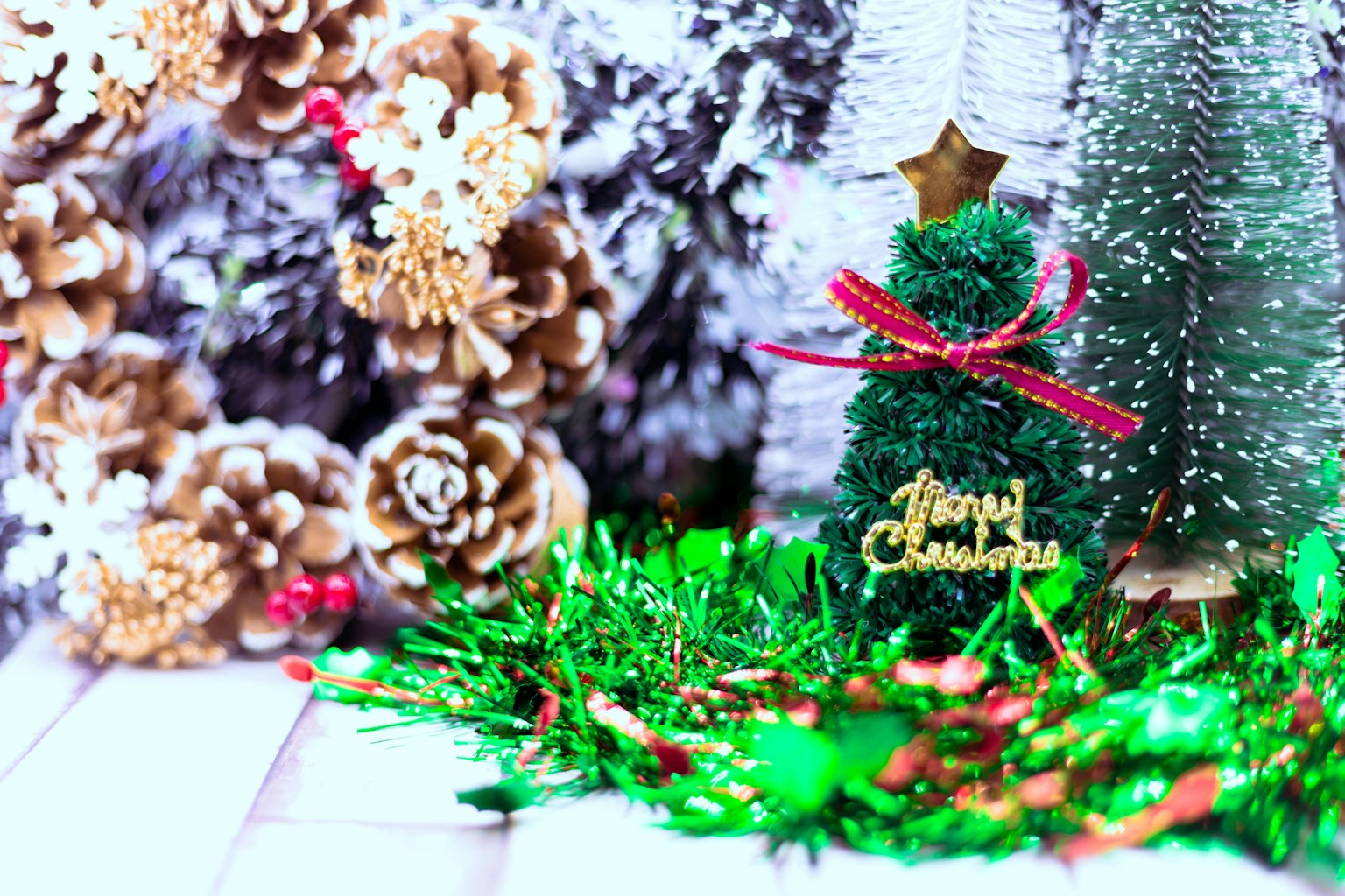 Un pequeño árbol de Navidad verde con una estrella y cinta rodeado de decoraciones festivas