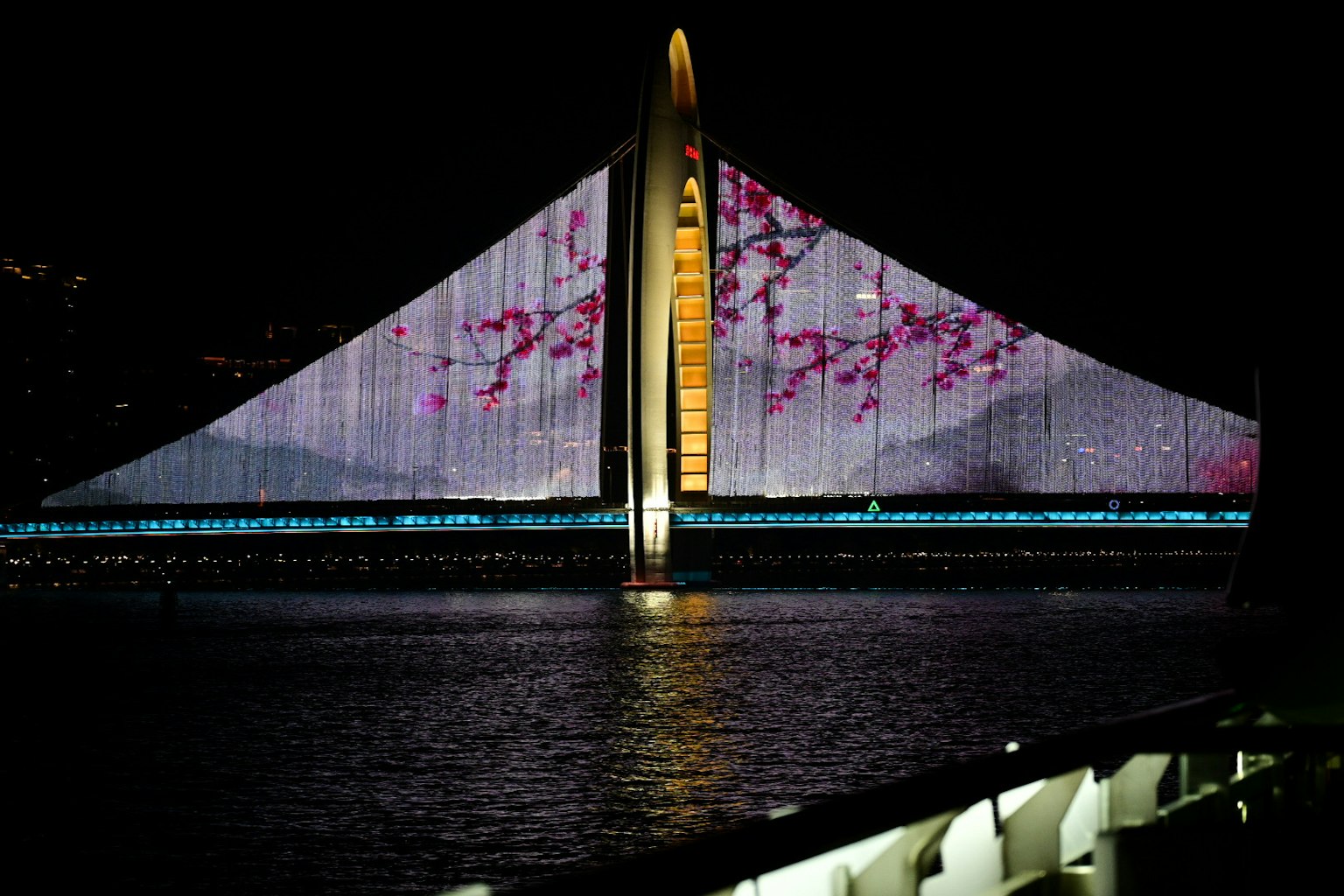 夜の光で照らされた美しい橋の景色 桜の花のデザインが映し出されている