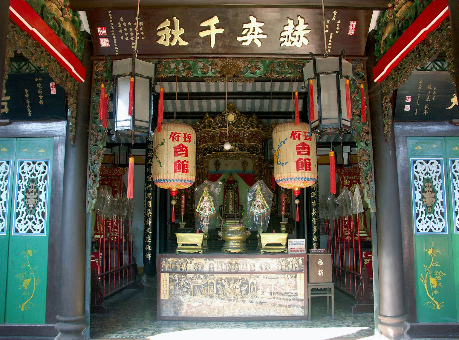Entrada de un templo chino tradicional con un altar y faroles
