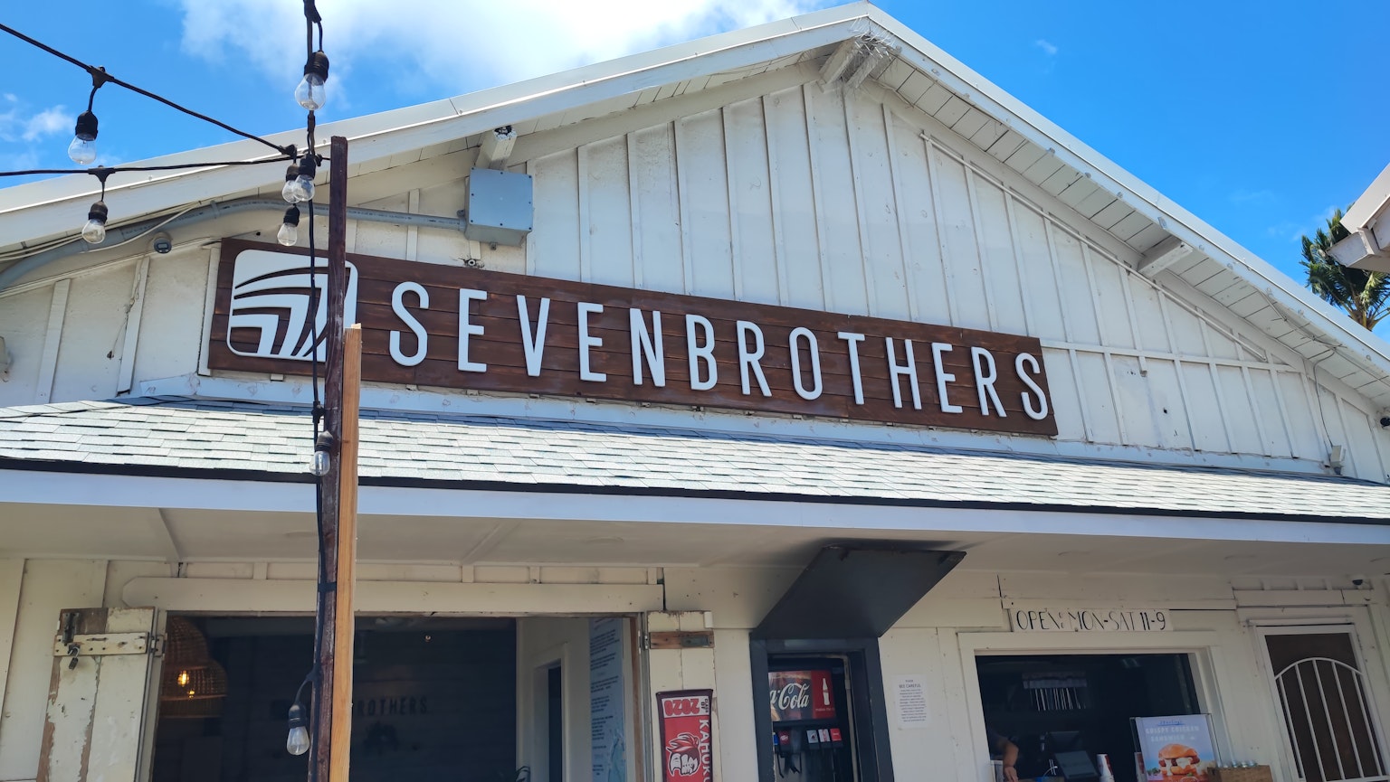 ภายนอกอาคาร Seven Brothers พร้อมท้องฟ้าสีฟ้าและผนังสีขาว