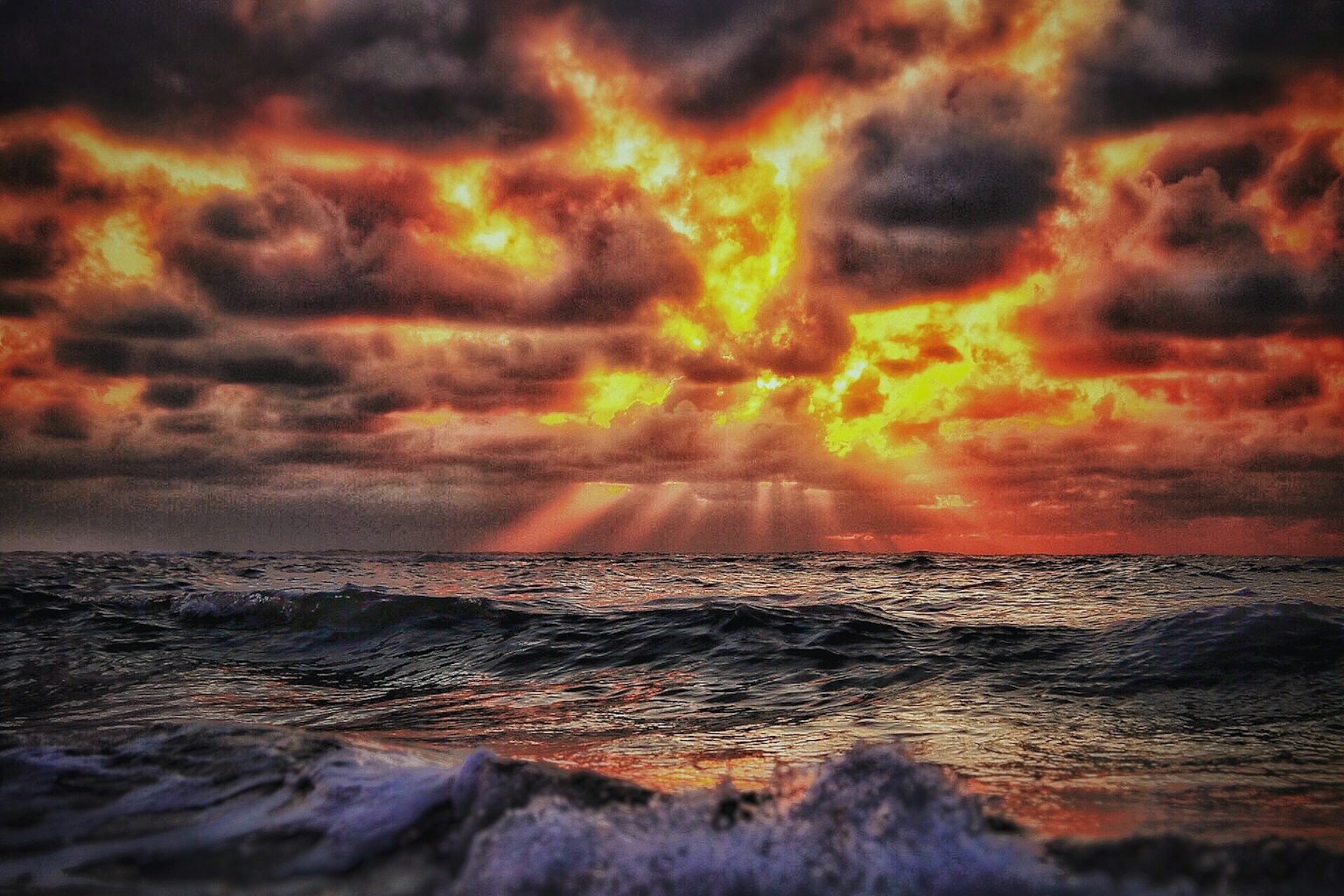 Magnifique paysage maritime au coucher du soleil avec des nuages sombres et des rayons de lumière orange