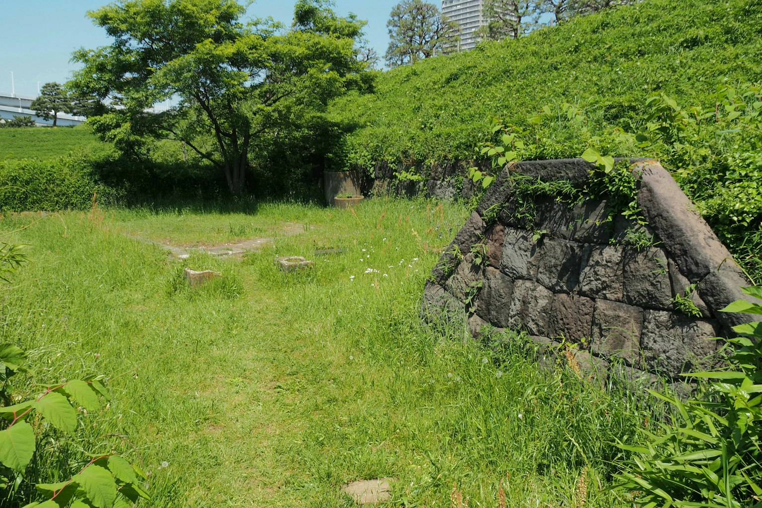 Old stone structure surrounded by green grass and a pathway