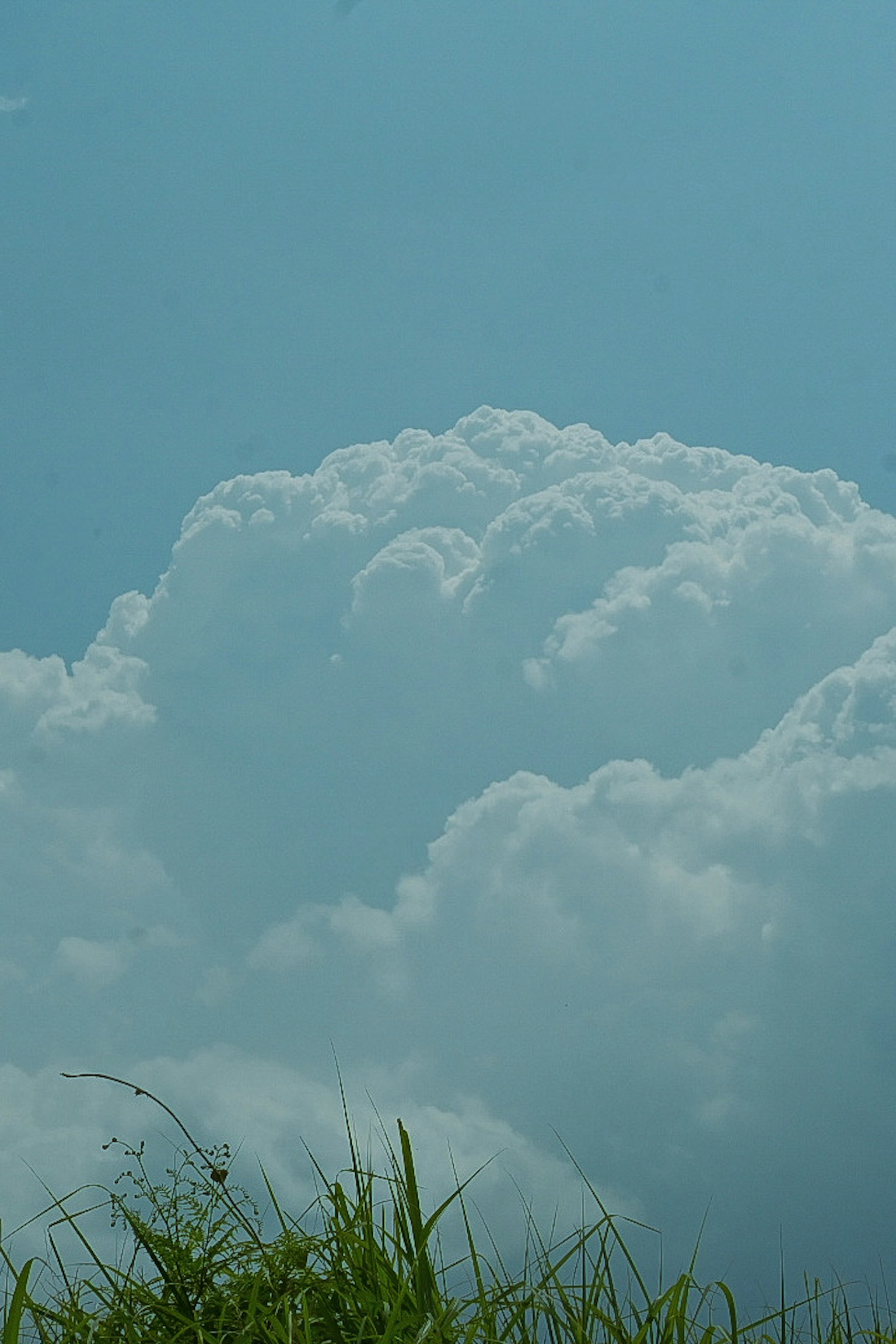 Eine Landschaft mit weißen Wolken vor einem blauen Himmel