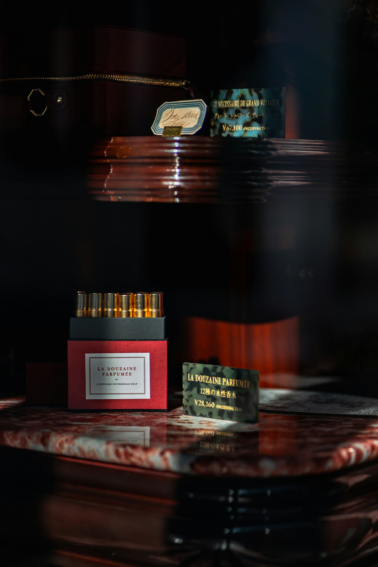 Image of a shelf displaying small bottles in a red box and decorative items